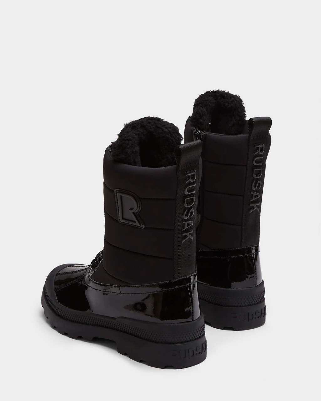 The Rudsak LEX - 8224534 Black are women’s mid-calf winter boots in shiny black patent leather with thick rubber soles, fuzzy wool-lined interiors, and Rudsak branding on the back heel and sides.