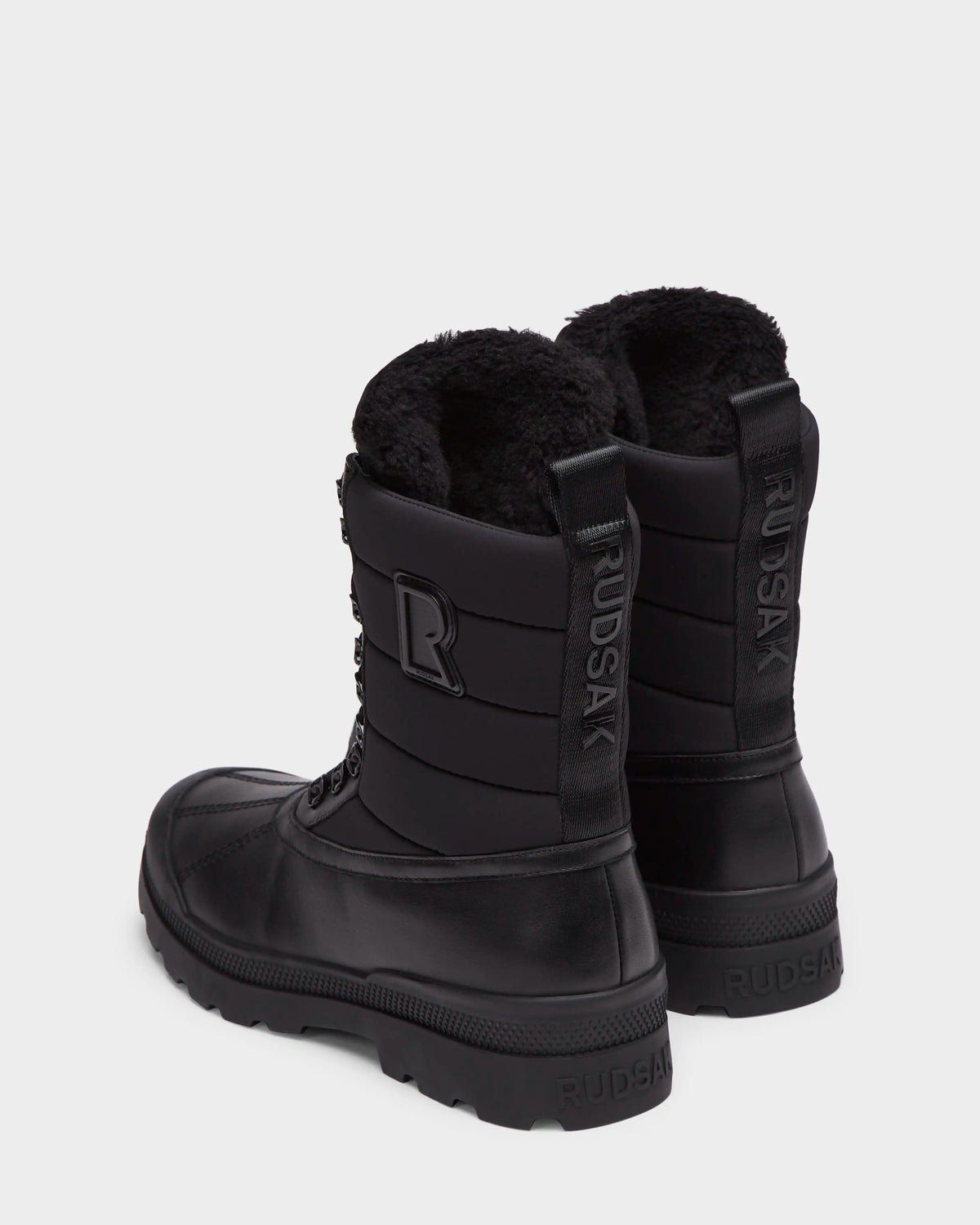 RUDSAK REAGAN - 6225046 Black men’s winter boots featuring quilted shafts, faux-fur lining, and lugged rubber soles.