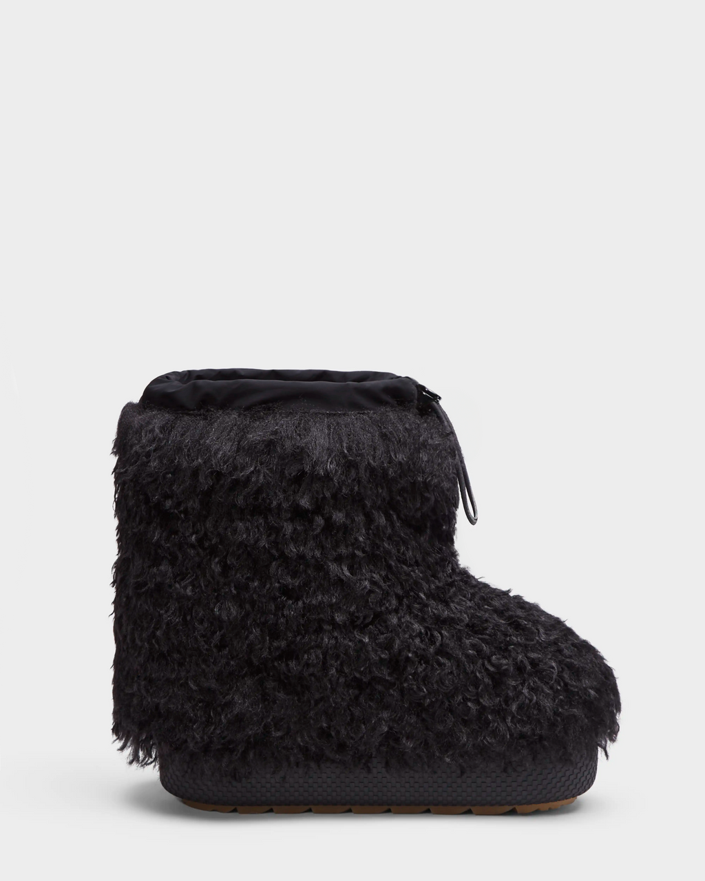 The Rudsak ROSSY - 8224518 Black is a women's slip-on winter boot featuring a thick, textured Mongolian fur exterior, rounded toe, and top drawstring closure, shown against a plain white background.
