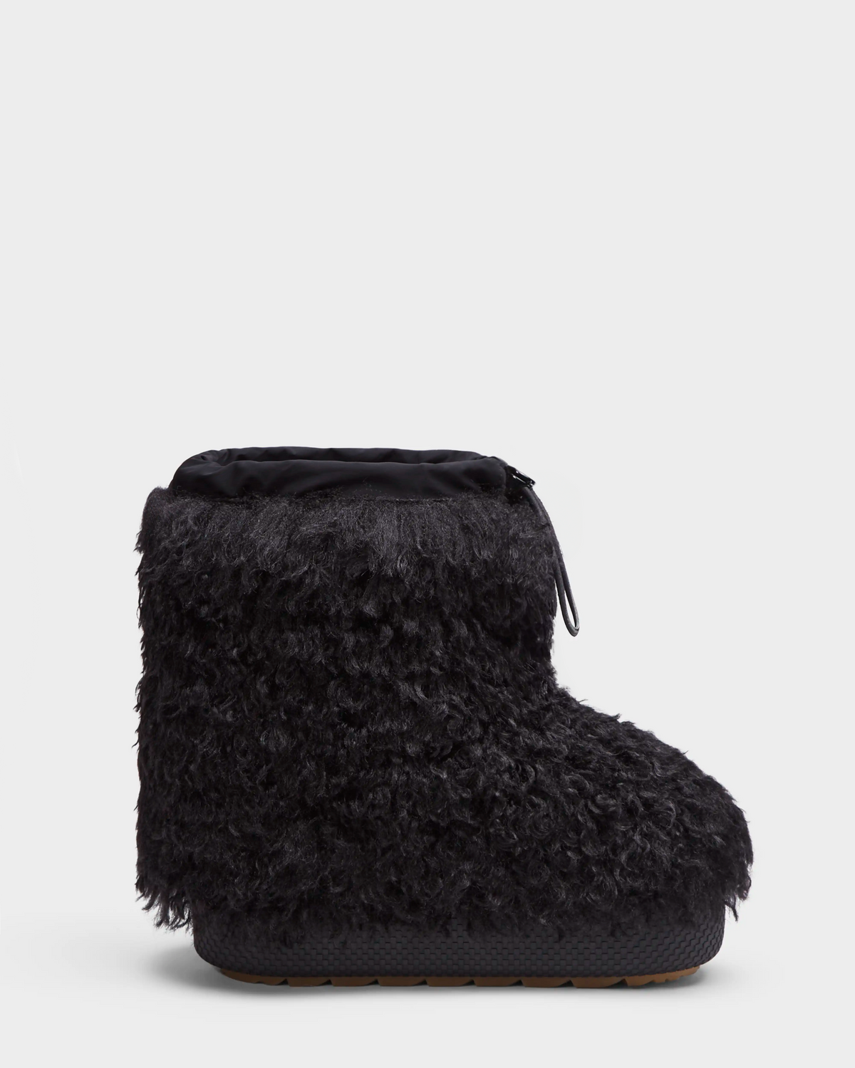 The Rudsak ROSSY - 8224518 Black is a women's slip-on winter boot featuring a thick, textured Mongolian fur exterior, rounded toe, and top drawstring closure, shown against a plain white background.