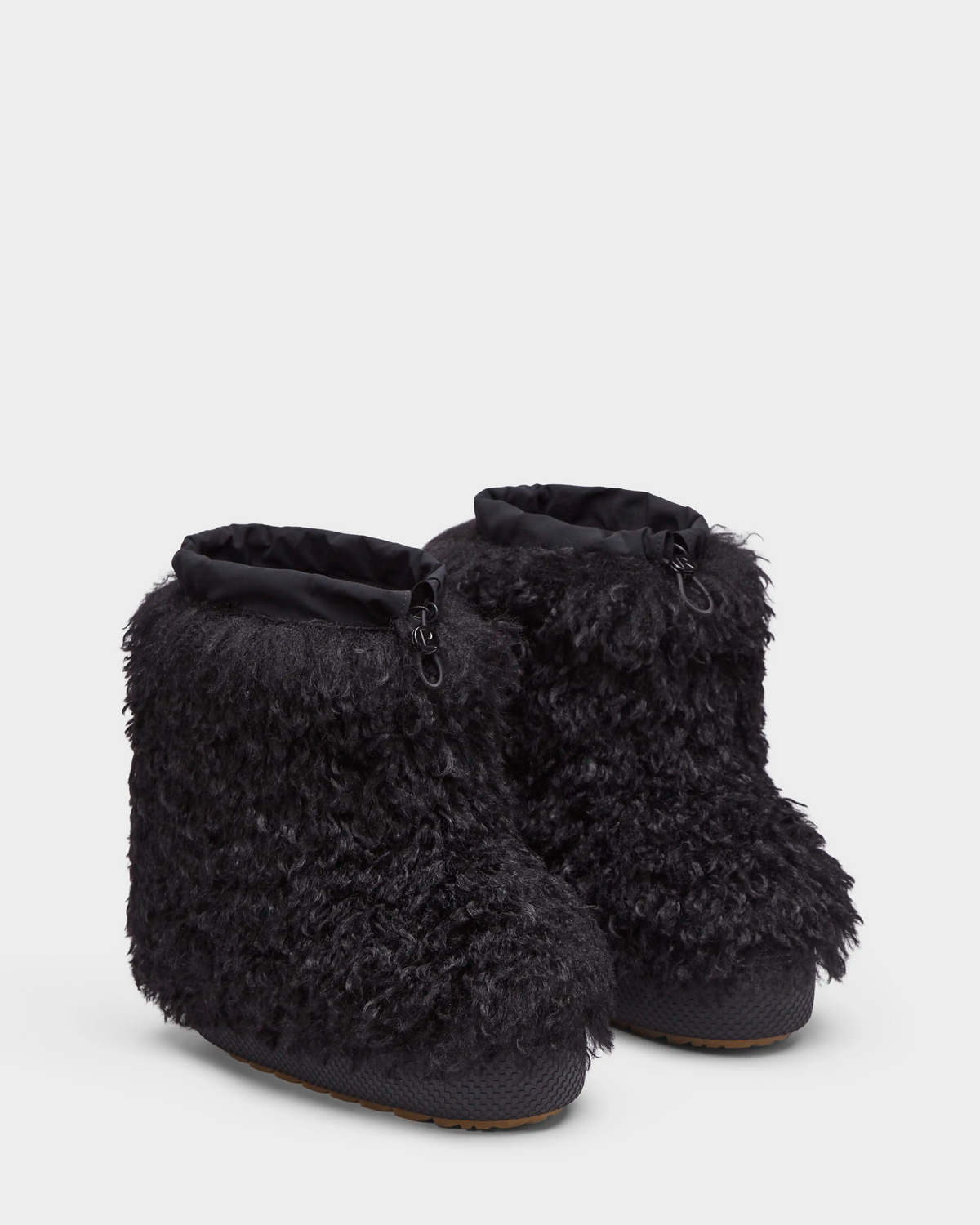 The Rudsak ROSSY - 8224518 Black boots are women's slip-on winter boots with a textured faux Mongolian fur exterior, drawstring top closures, and thick soles for a warm, cozy feel.