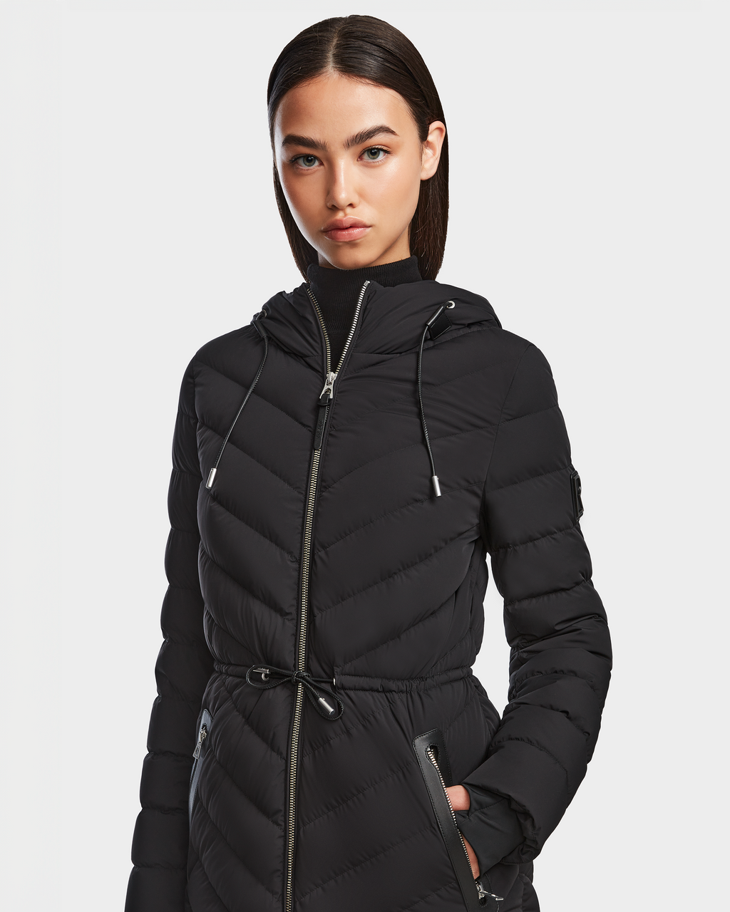 A woman in the Rudsak FRANCINE - 8124722 Black RDS-certified down quilted puffer coat.