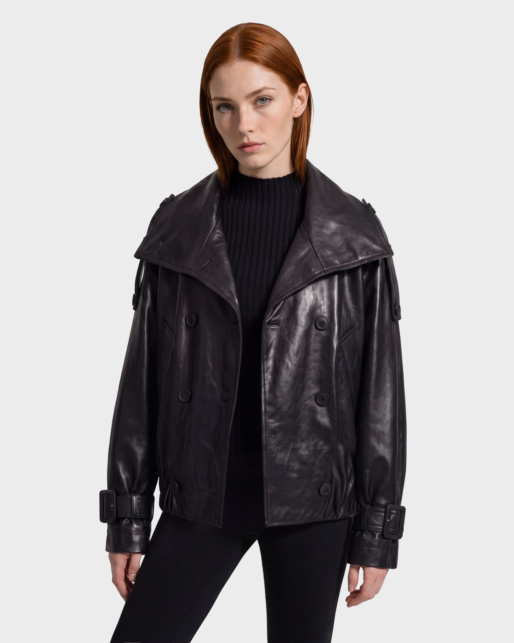 A person wears the JANELLE - 8126936 Black Rudsak bomber, a black leather jacket with a wide collar, buckled cuffs, and a modern silhouette.
