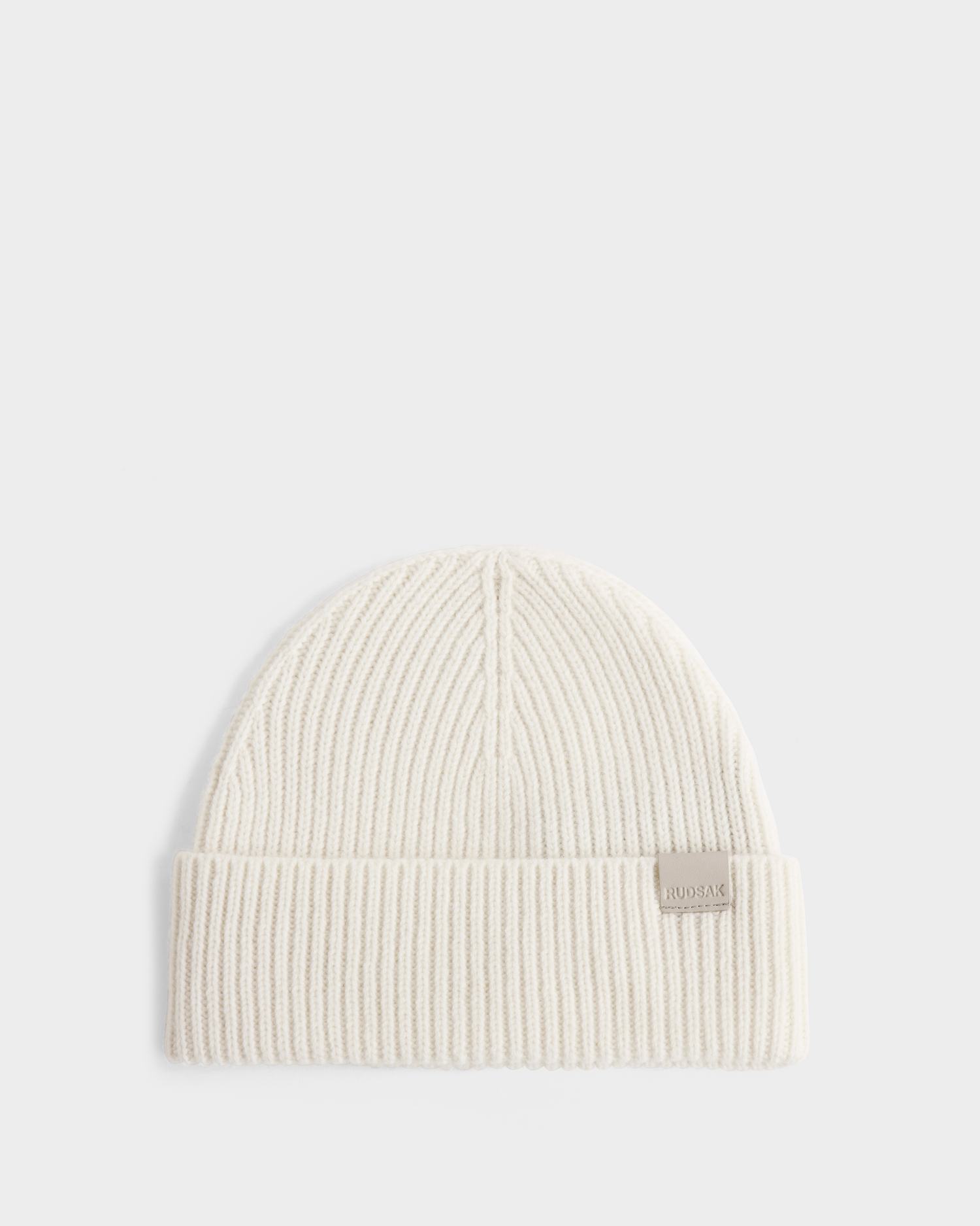 The Rudsak ANDREY - U425507 Vanilla beanie is a cream unisex, rib-knit hat with a folded brim and a small rectangular tag on the front, shown on a plain white background.