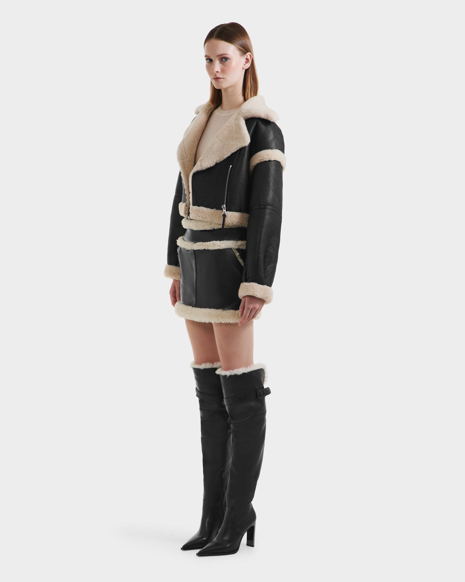 A woman stands out in the ARIANNA - 8125504 Black coat by Rudsak, a modern minimalist jacket featuring luxe shearling details.