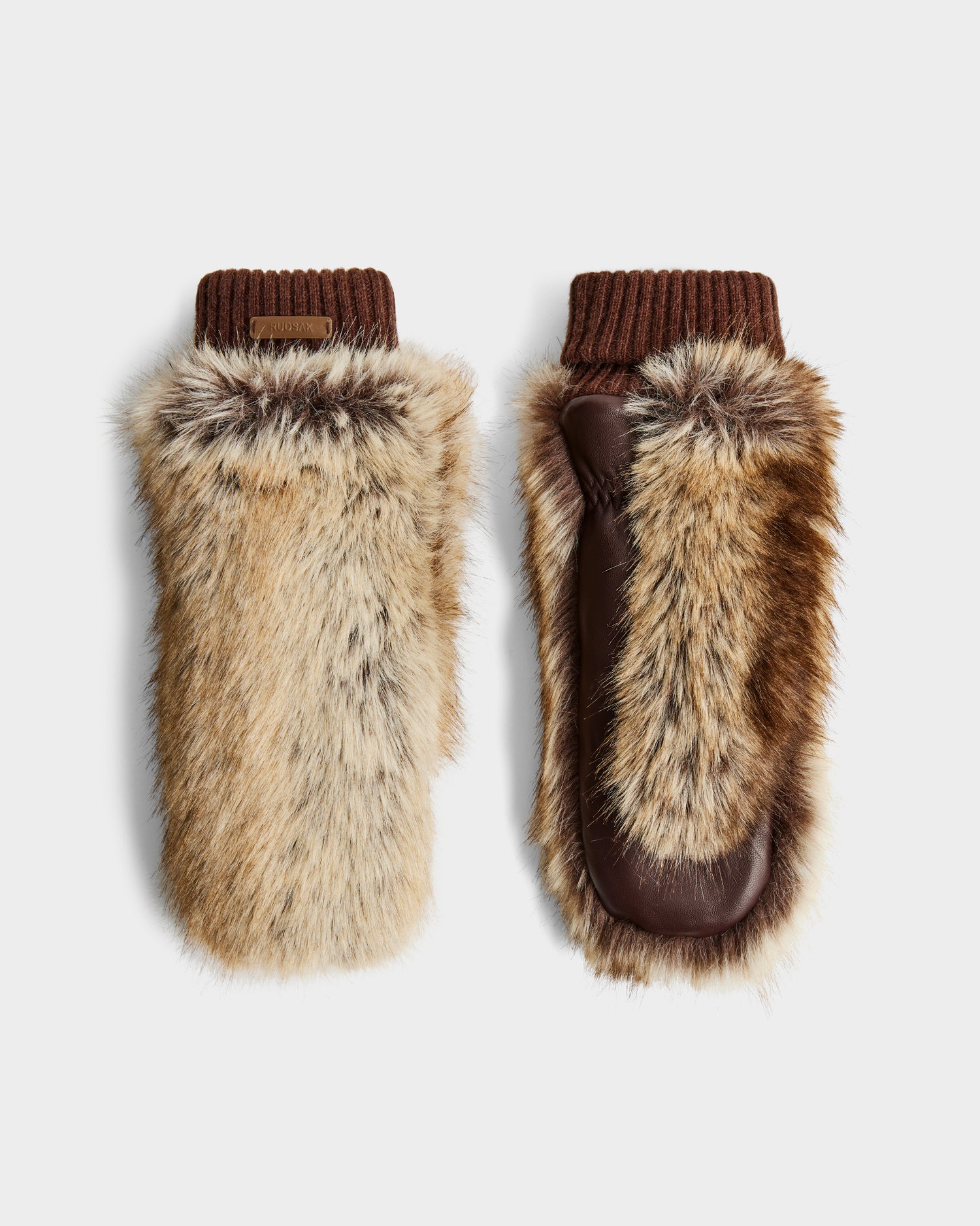The BELLA - 8425006 Mix Mocha mittens by Rudsak feature faux fur in tan, brown, and cream, with brown leather palms and knitted cuffs—an essential winter accessory. Shown against a plain white background.