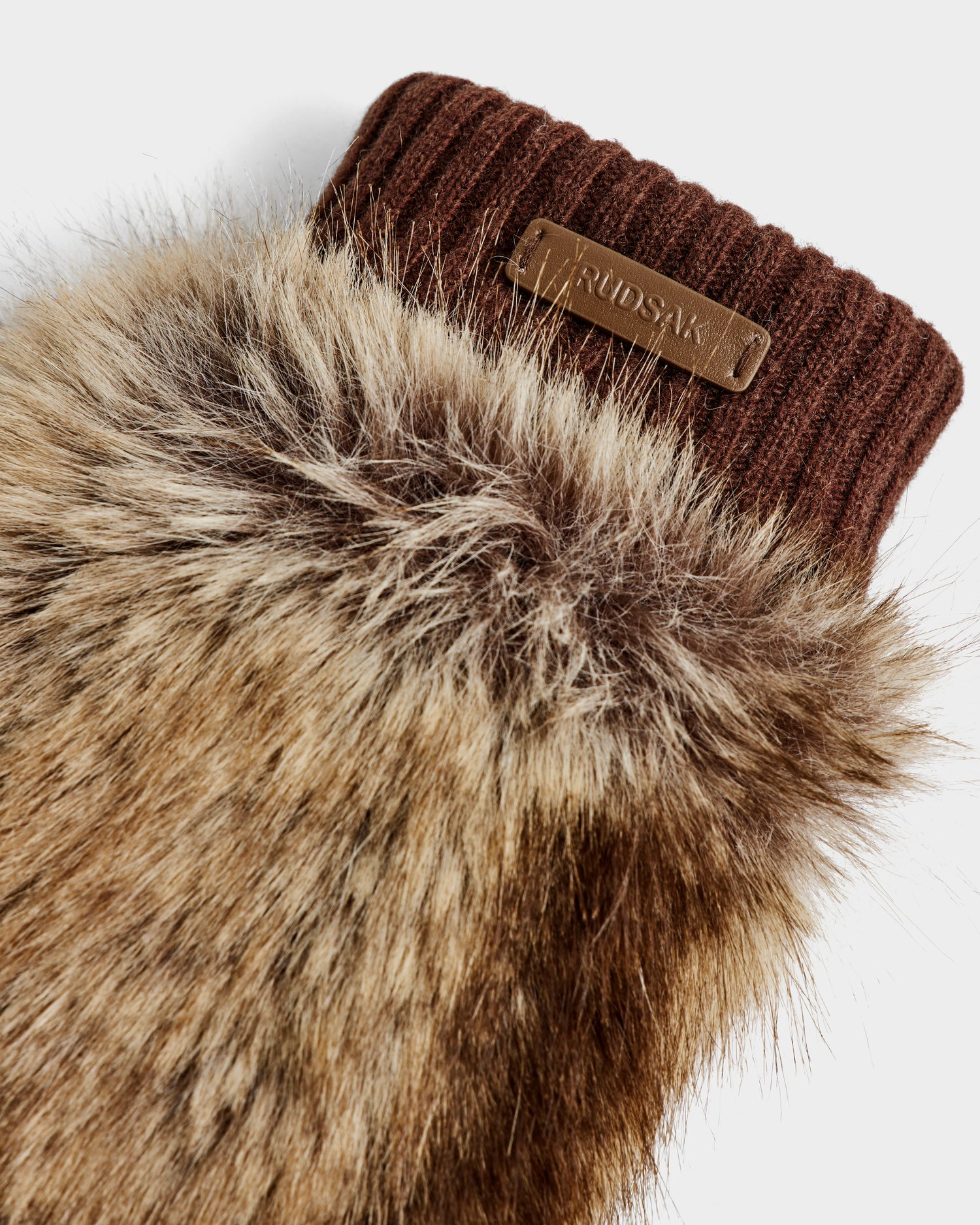 A close-up of the BELLA - 8425006 Mix Mocha mitten by Rudsak, featuring brown faux fur, a ribbed knit cuff, and a small leather patch—an elegant winter accessory.