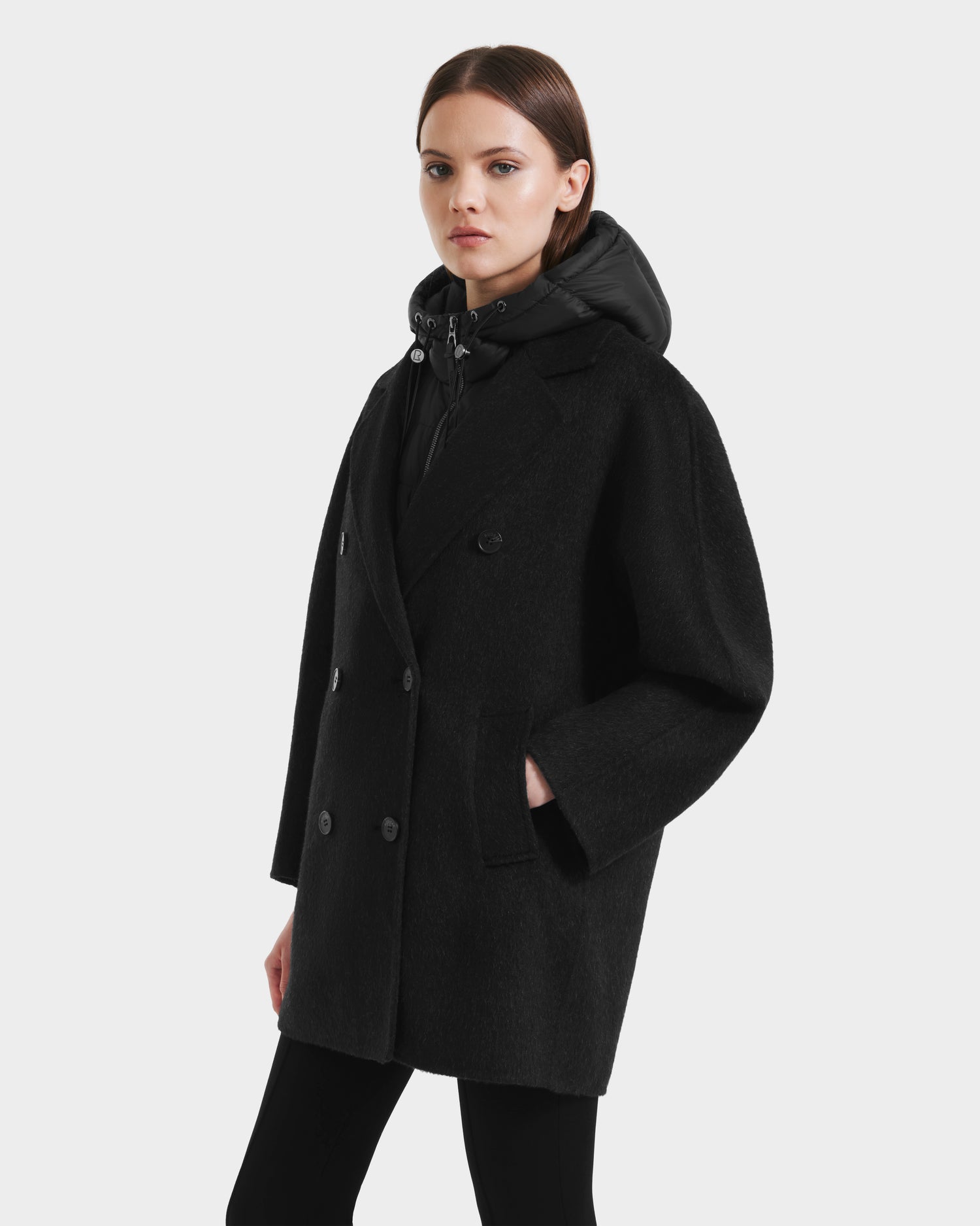 A woman wears the Rudsak BETHANY - 8125625 Black coat, exuding timeless elegance with its modular wool-silk-yak outerwear design.