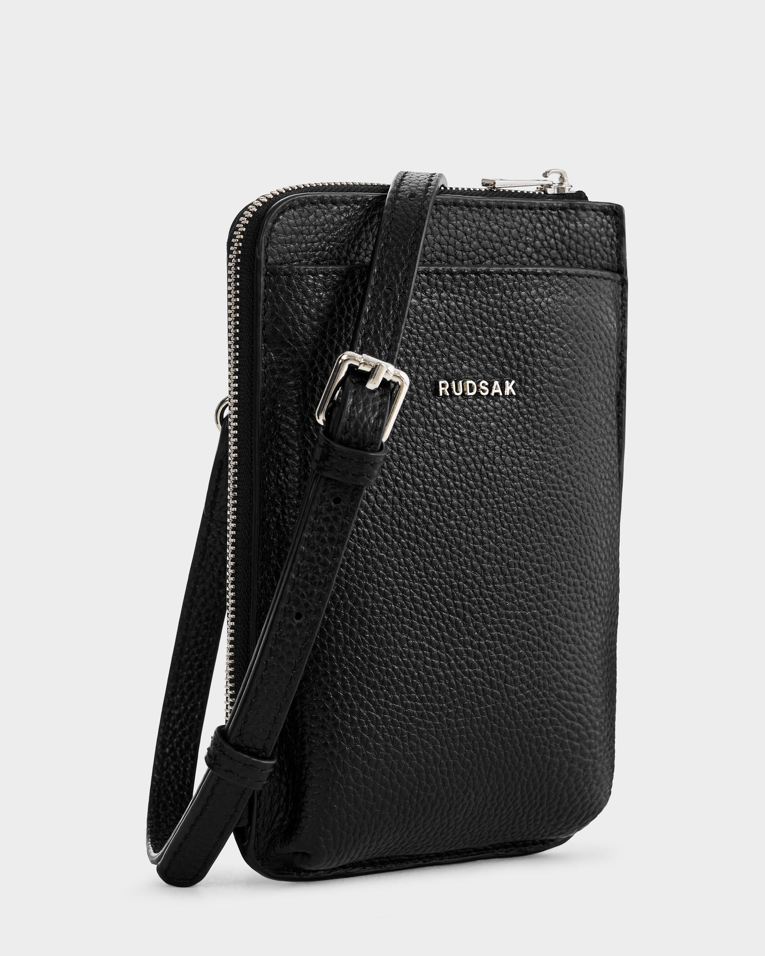 The CELYN - L325514 Black by Rudsak is a black pebbled leather women’s crossbody with a slim zippered pocket, adjustable strap, and silver Rudsak logo—your perfect go-to city bag.