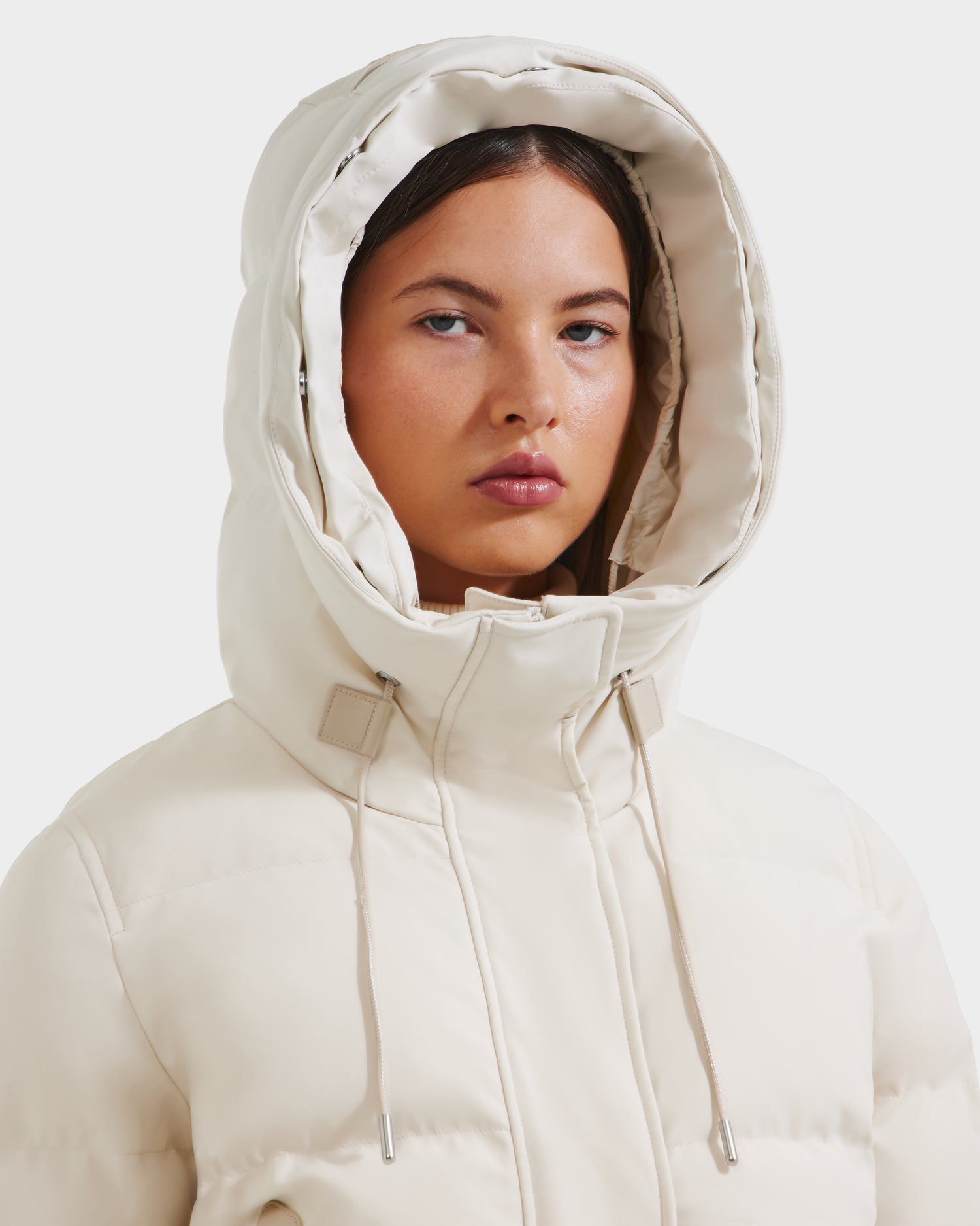 A woman wears the Rudsak CIEYNA - 8125579 Vanilla bomber jacket with its hood up, looking directly at the camera against a plain white background.