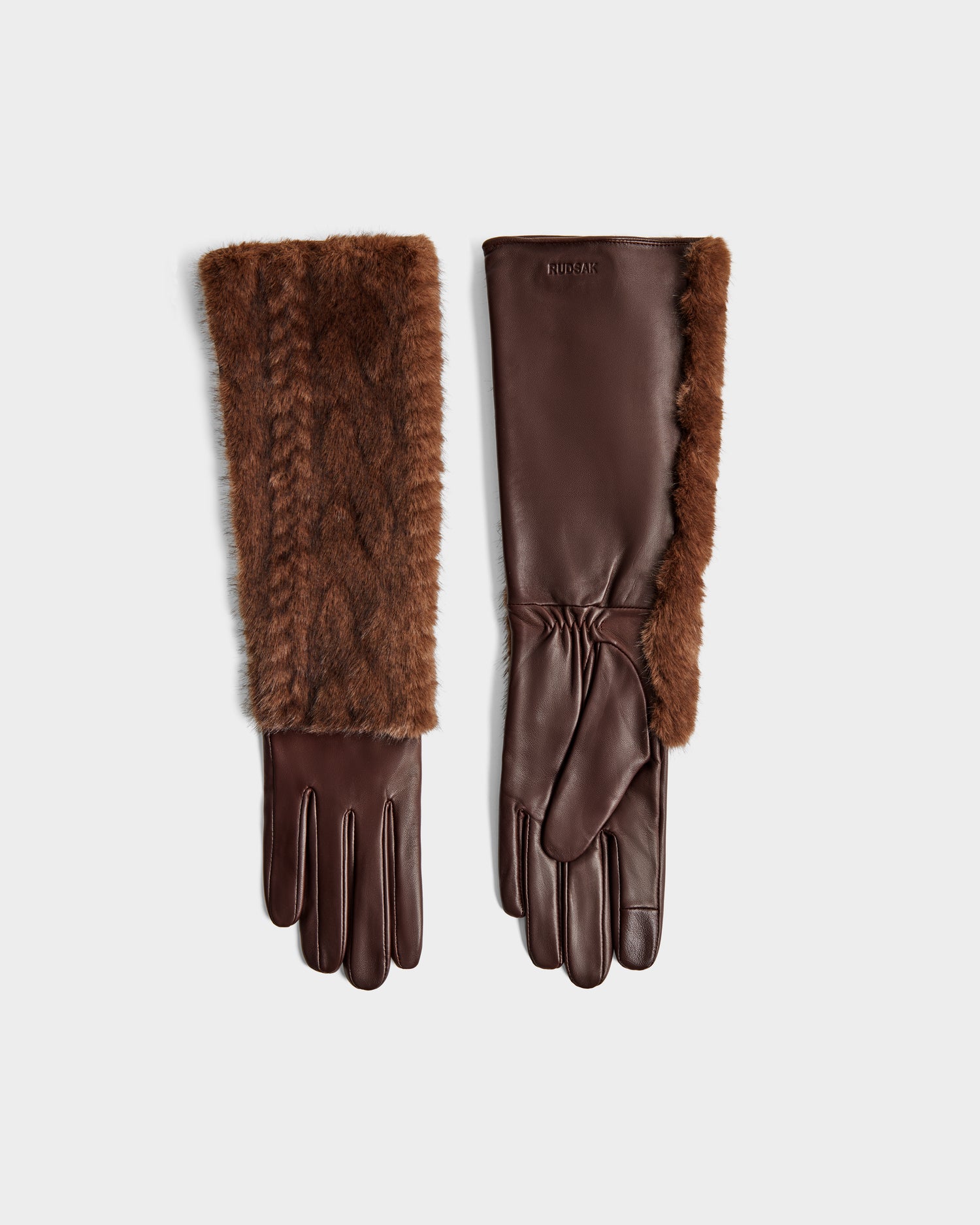 The Rudsak COVE - 8425533 Mocha gloves feature brown leather and soft faux fur trim on the cuffs, shown flat with one glove displaying the fur detail and the other exposing the smooth leather finish against a light backdrop.