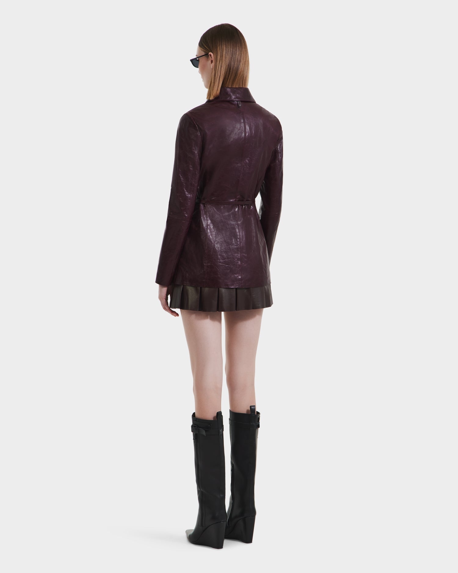 A woman in the Rudsak DANICA - 8125025 Bordeaux leather jacket and boots.