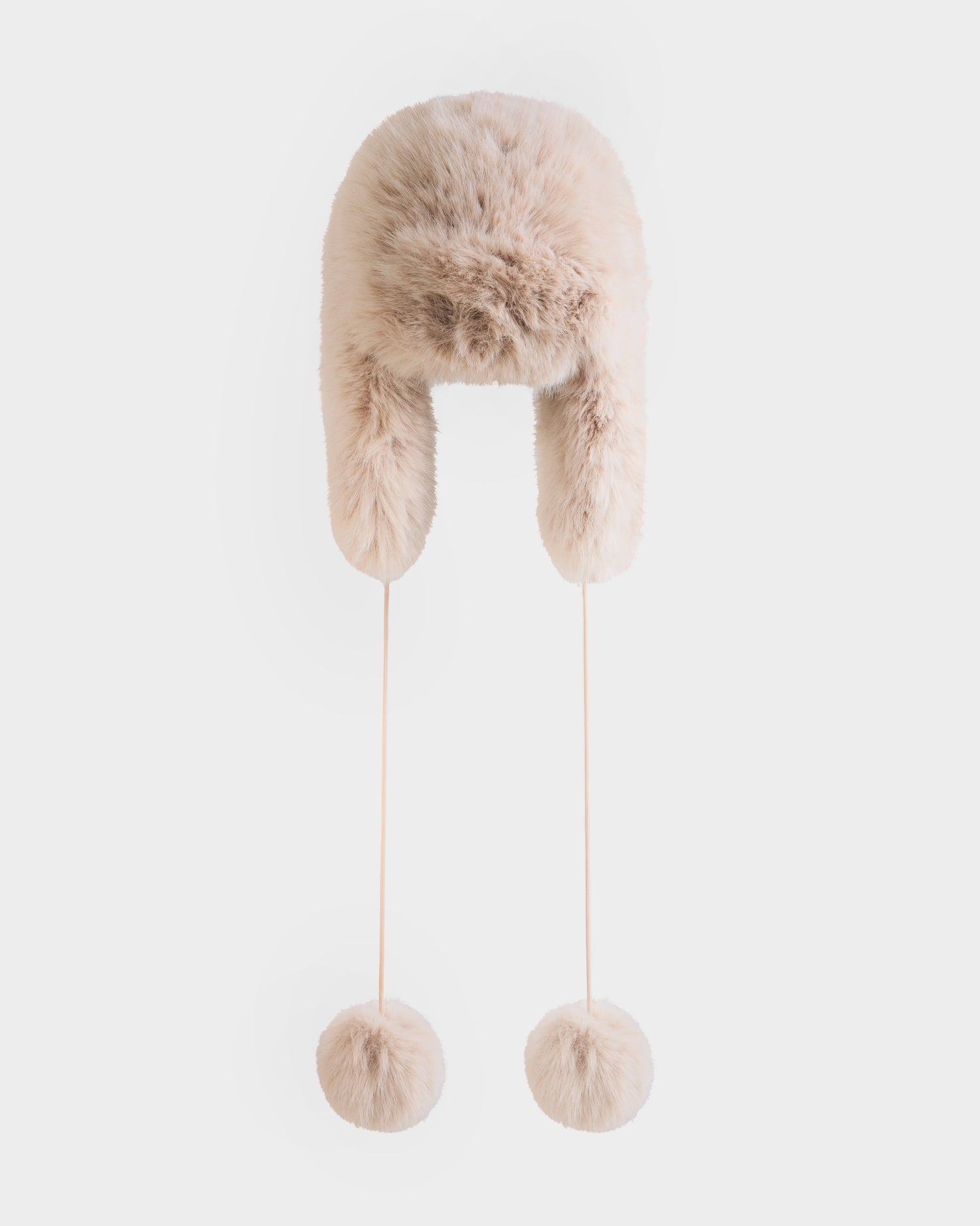 The DEMI - L425539 Vanilla by Rudsak is a fluffy, light beige women’s faux-fur aviator hat with long strings ending in matching fur pom-poms, shown against a plain white background.