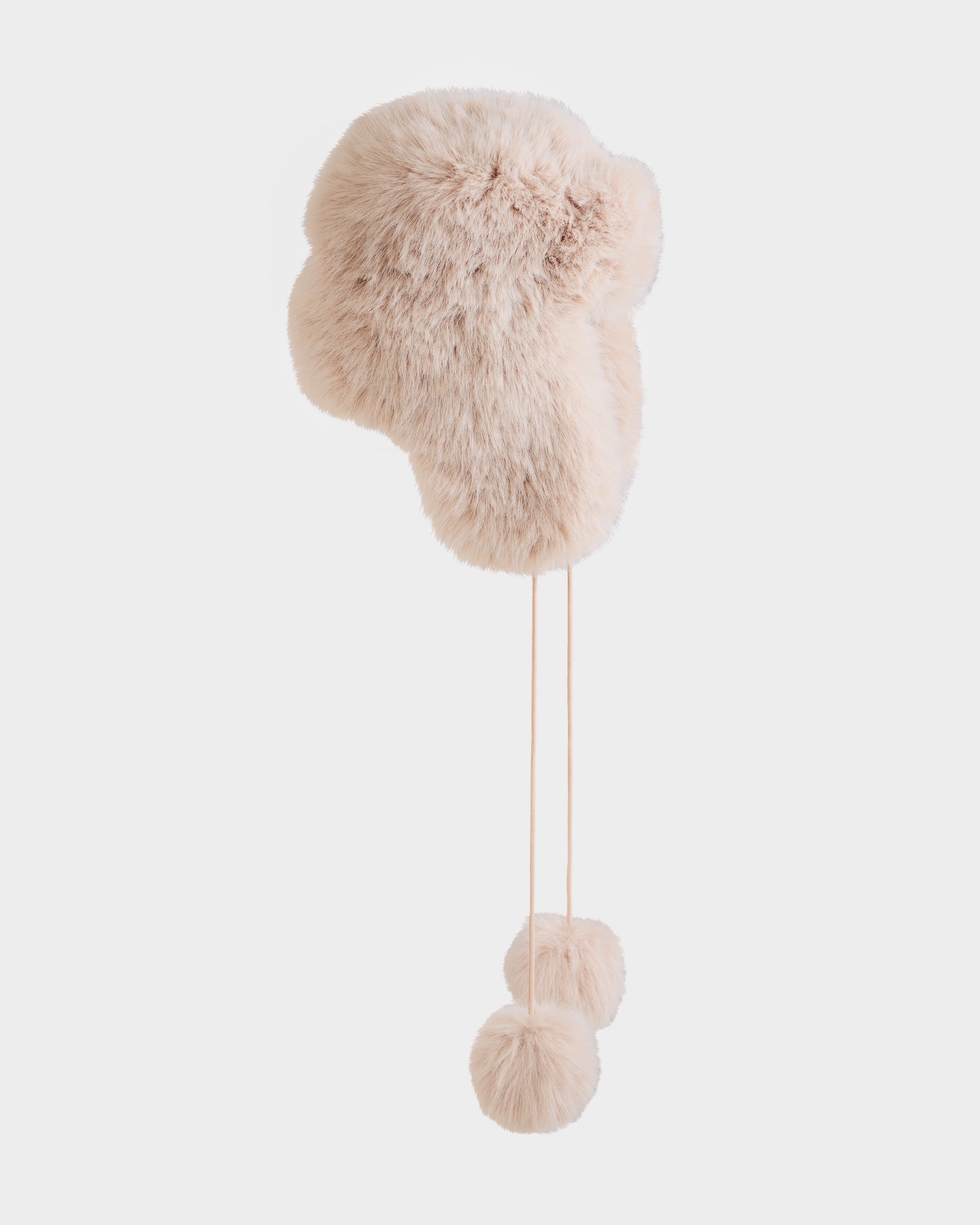 The Rudsak DEMI - L425539 Vanilla is a light pink women’s faux-fur aviator hat with ear flaps and two fluffy pom-poms on strings, shown against a plain white background.