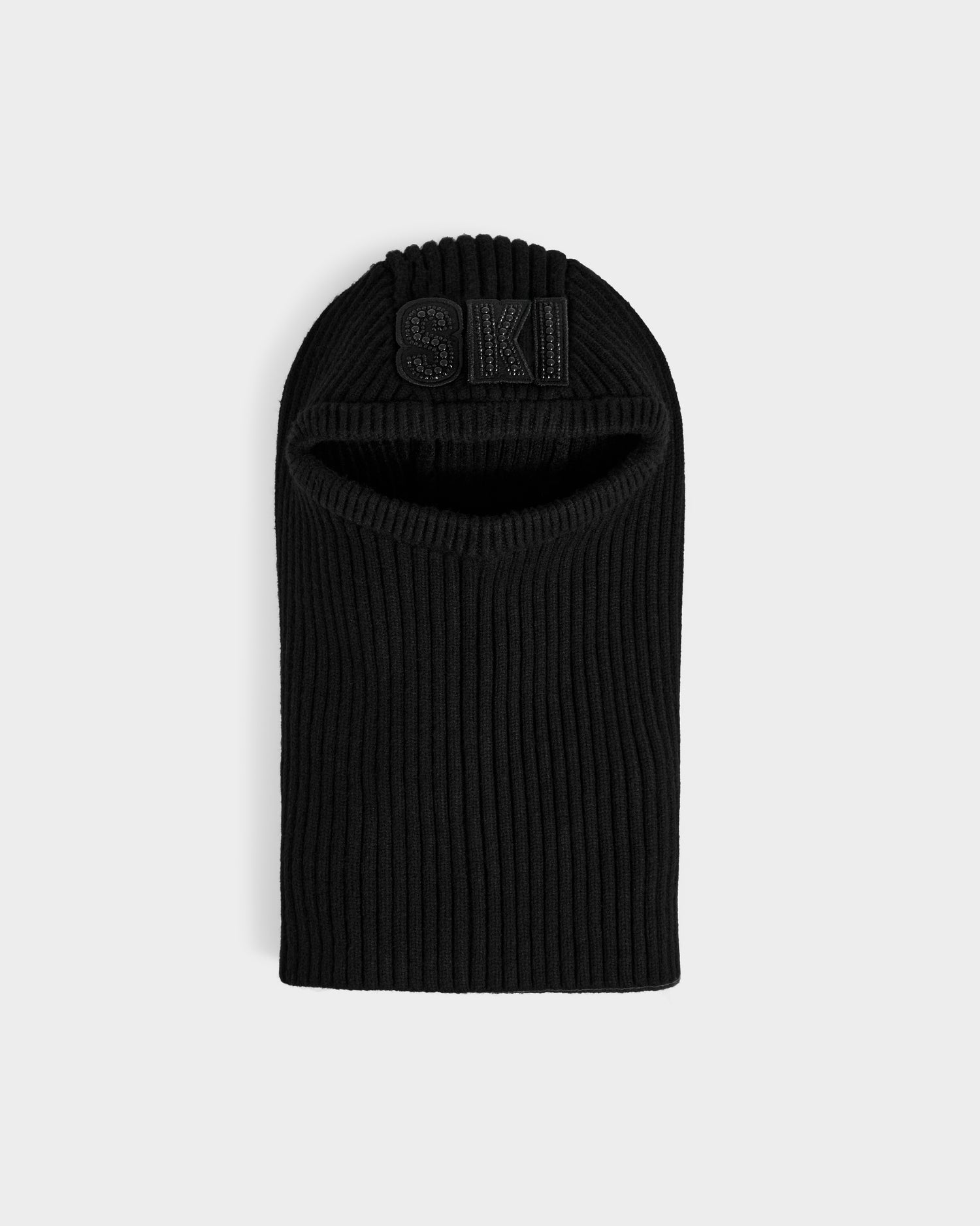 The DIXIE - 8425551 Black by Rudsak is a women’s knit balaclava with a ribbed finish, eye and mouth openings, and SKI embroidered on the forehead—perfect for winter style. Shown against a plain light background.