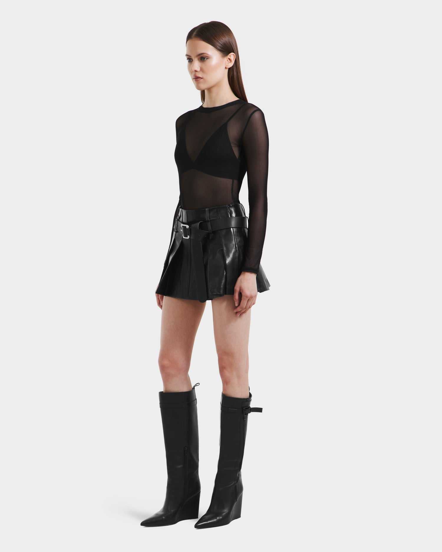 A woman wears the Rudsak FELICITY - 8525650 Black, a chic high-waisted leather skirt.