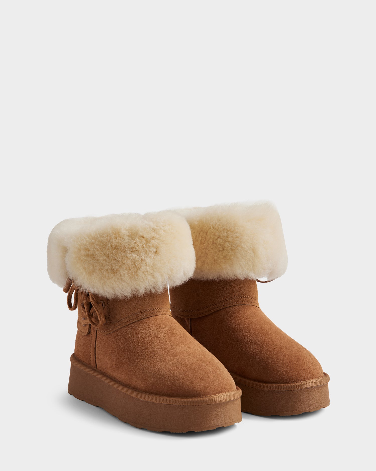 The Rudsak INESA - L225026 Tan women's suede platform boots feature thick creamy white wool lining at the top and a lightweight sole, displayed side by side on a plain light background.