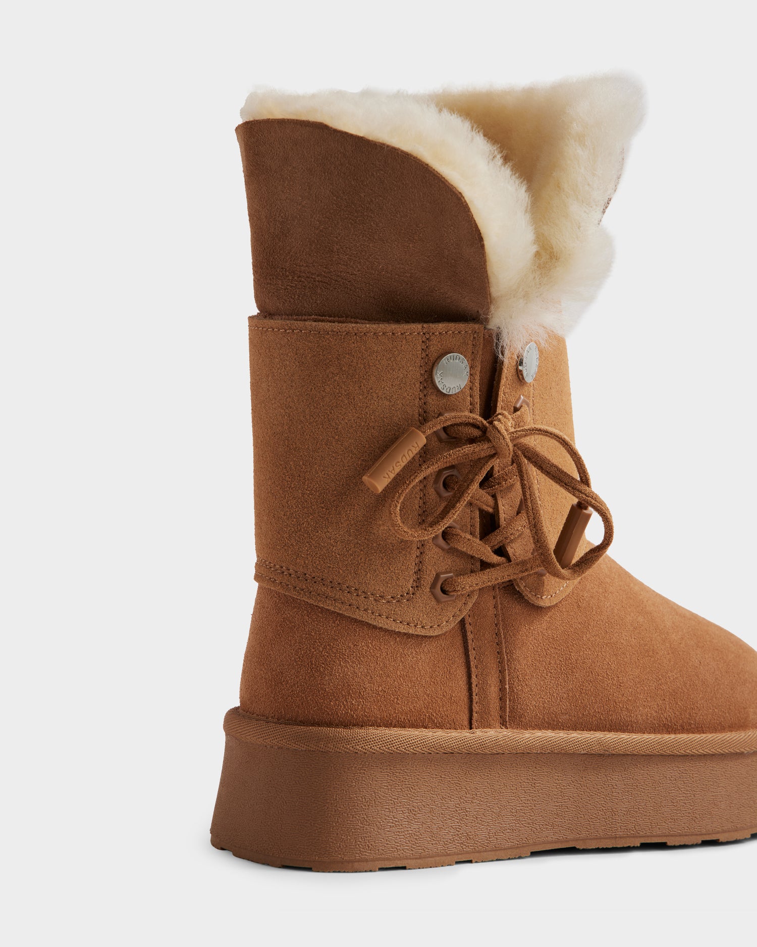 The Rudsak INESA - L225026 Tan is a women’s brown suede platform boot featuring a lace-up front, thick lightweight sole, and plush white wool lining visible at the opening. Side view shown on a plain white background.