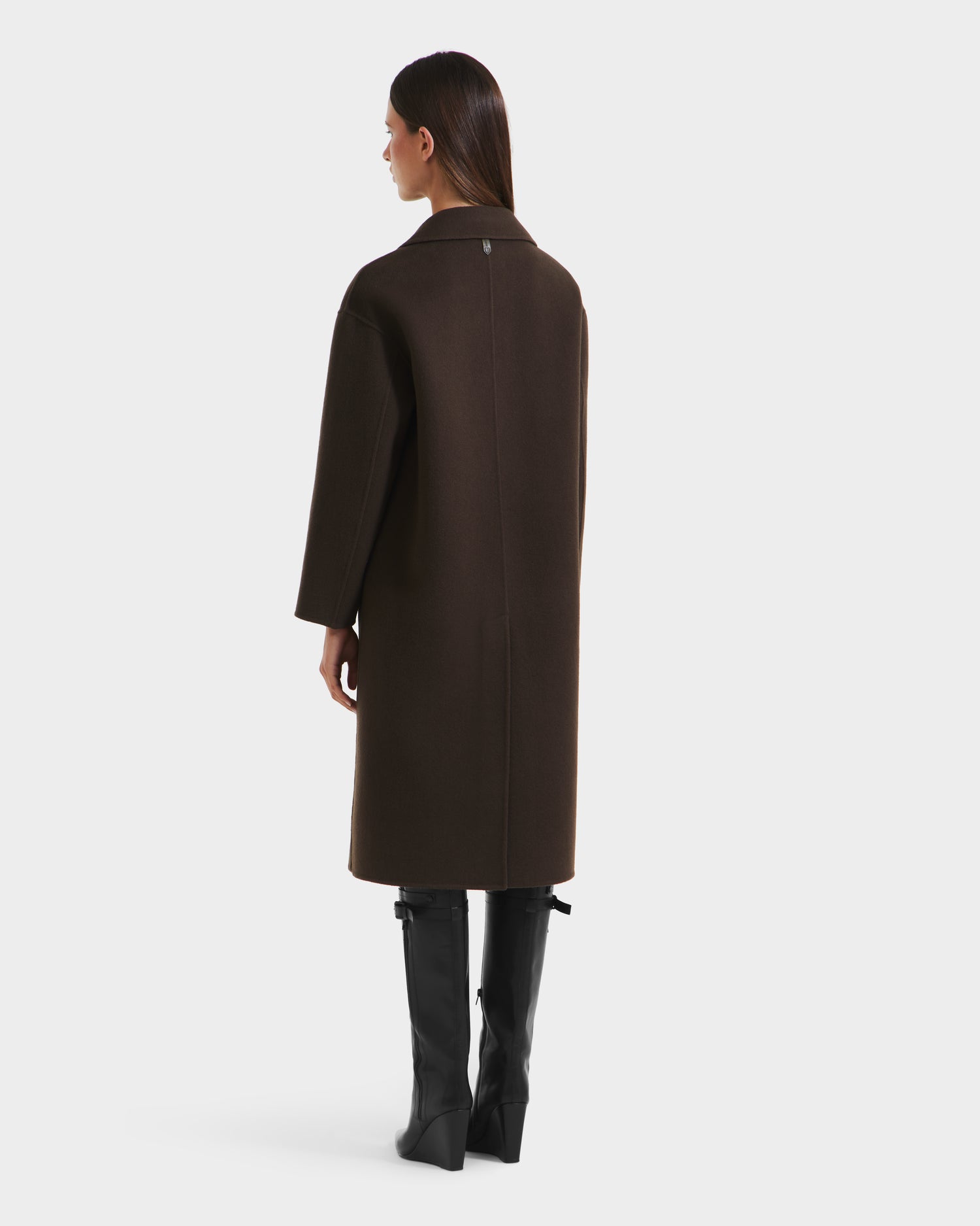 A woman with straight brown hair models the Rudsak JADE - 8125673 Army womens wool overcoat, standing and facing away on a plain white background.
