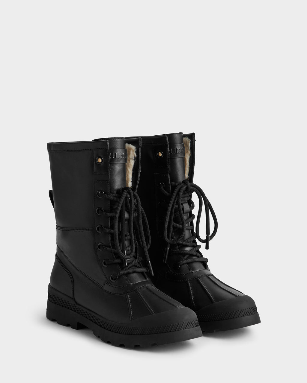 The Rudsak JESI - 8225026 Black women’s boots feature a winter-ready lace-up design with rugged soles, round toes, visible faux fur lining, metal eyelets, textured rubber base, and stylish durable leather accents.