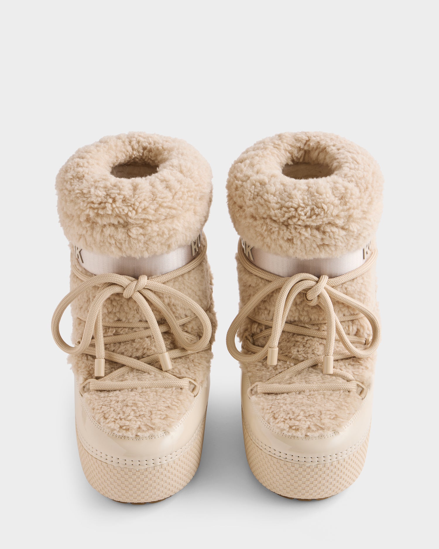 The Rudsak KATHY - 8223513 Vanilla women's winter boots feature beige faux shearling uppers, thick round laces, and durable rubber soles, shown from above on a white background.