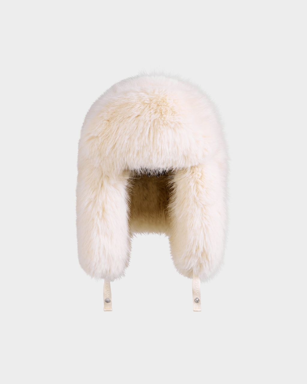 The Rudsak LIRA - 8425024 Vanilla is a women’s fluffy white faux fur aviator hat with ear flaps, inspired by après-ski style and Russian ushankas, shown against a plain light gray background.