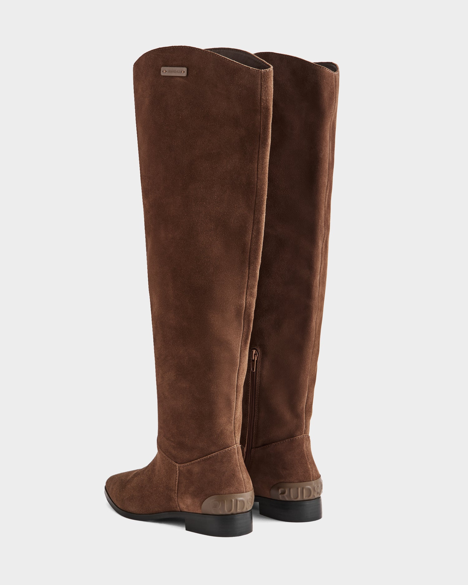 A pair of Rudsak MARSALLA - 8225033 Mocha women’s tall brown suede riding boots with low black heels and side zippers, displayed from the back and slightly to the side on a white background.