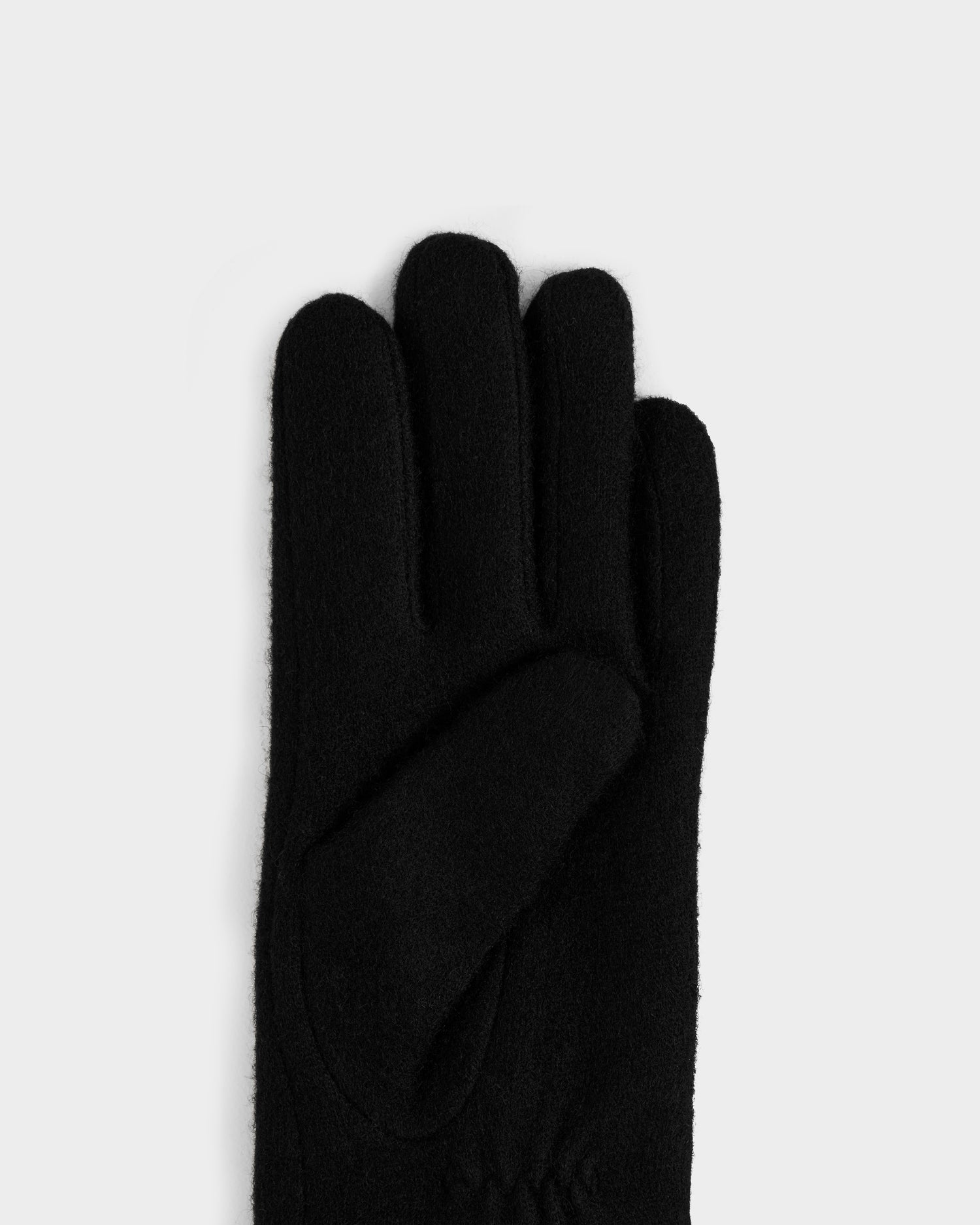 The OLGA - L425541 Black glove by Rudsak, crafted from soft fabric, is shown palm-up with fingers upright against a light gray background—a true cold-weather essential for any wardrobe.