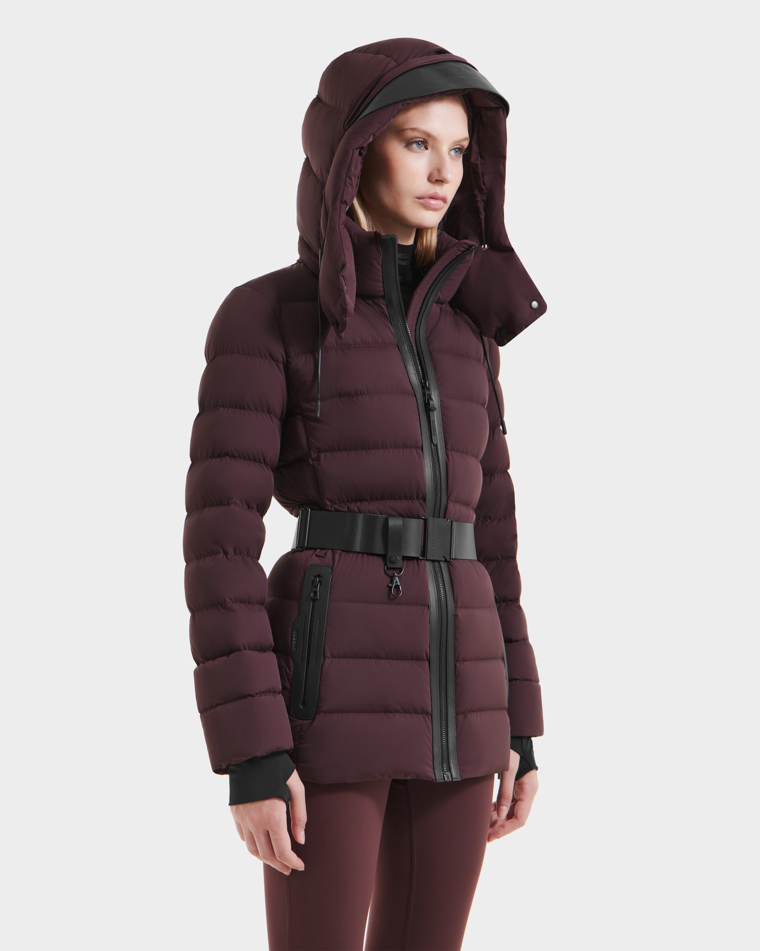 A woman stands confidently, wrapped in the warmth of her Rudsak PELIN S - 8124813 Bordeaux down puffer.