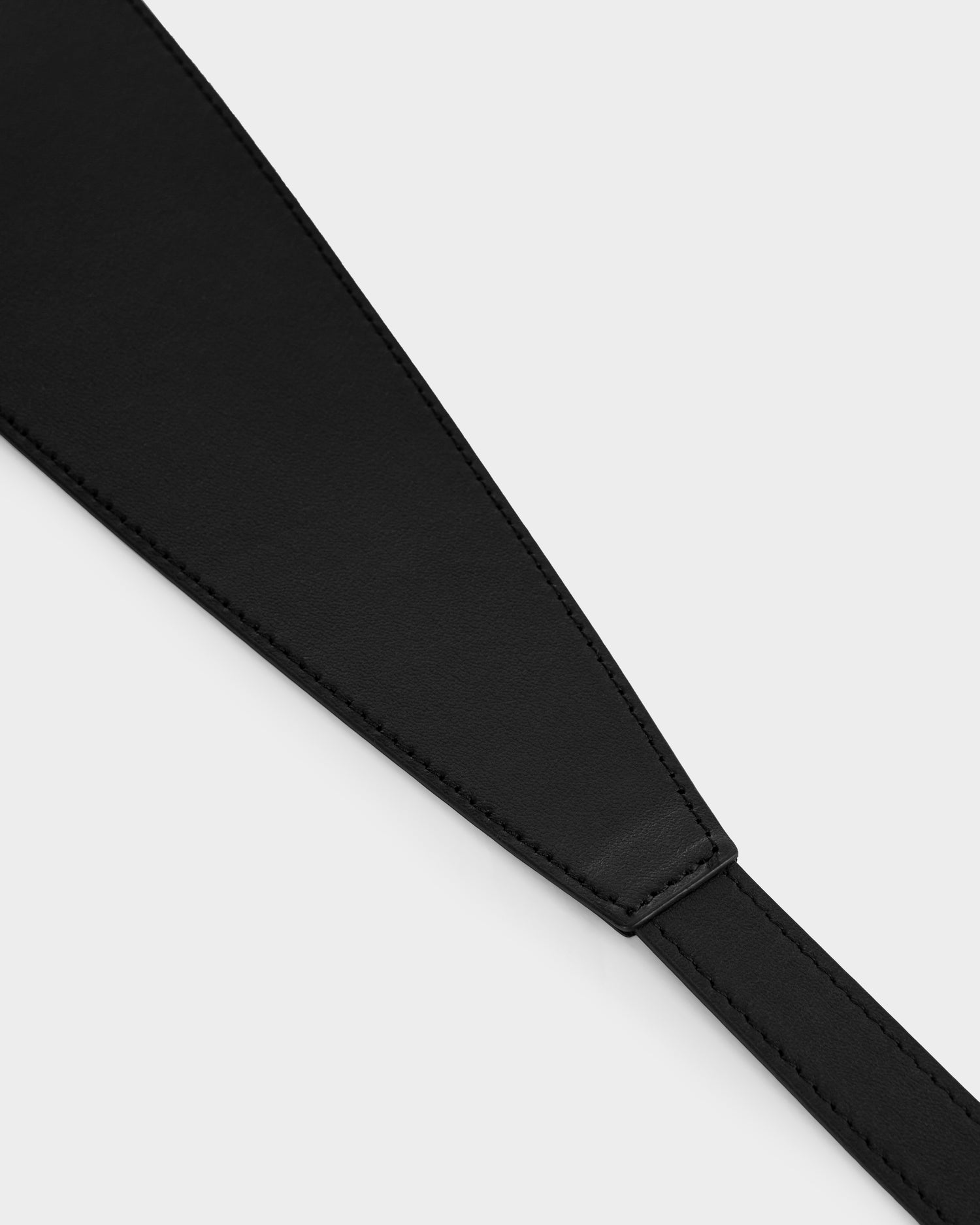 Close-up of the RENA - 8425039 Black leather strap by Rudsak, featuring neat stitching and a tapered design, shown against a plain light background.