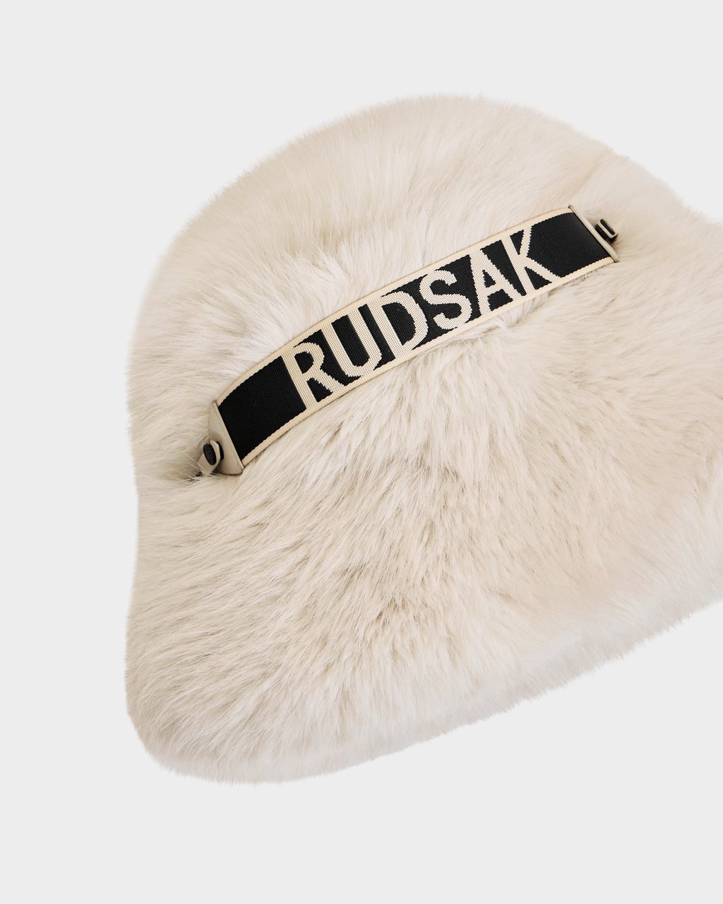 The Rudsak ROMINA - 8425545 Vanilla is a white faux fur bucket hat with a black strap featuring bold white RUDSAK lettering—an ultra-cozy, luxe women’s winter accessory shown on a plain white background.