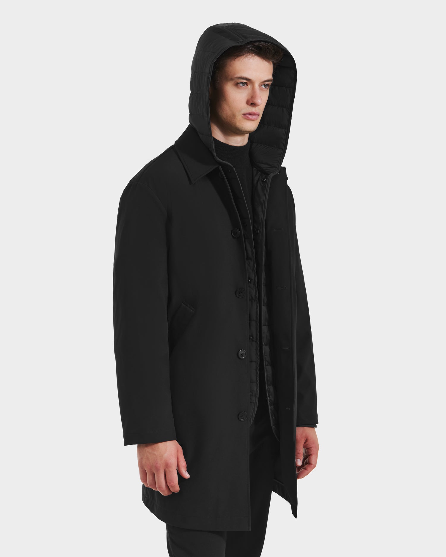 A man wearing the Rudsak STANTON - 6125531 Black weather-resistant overcoat.