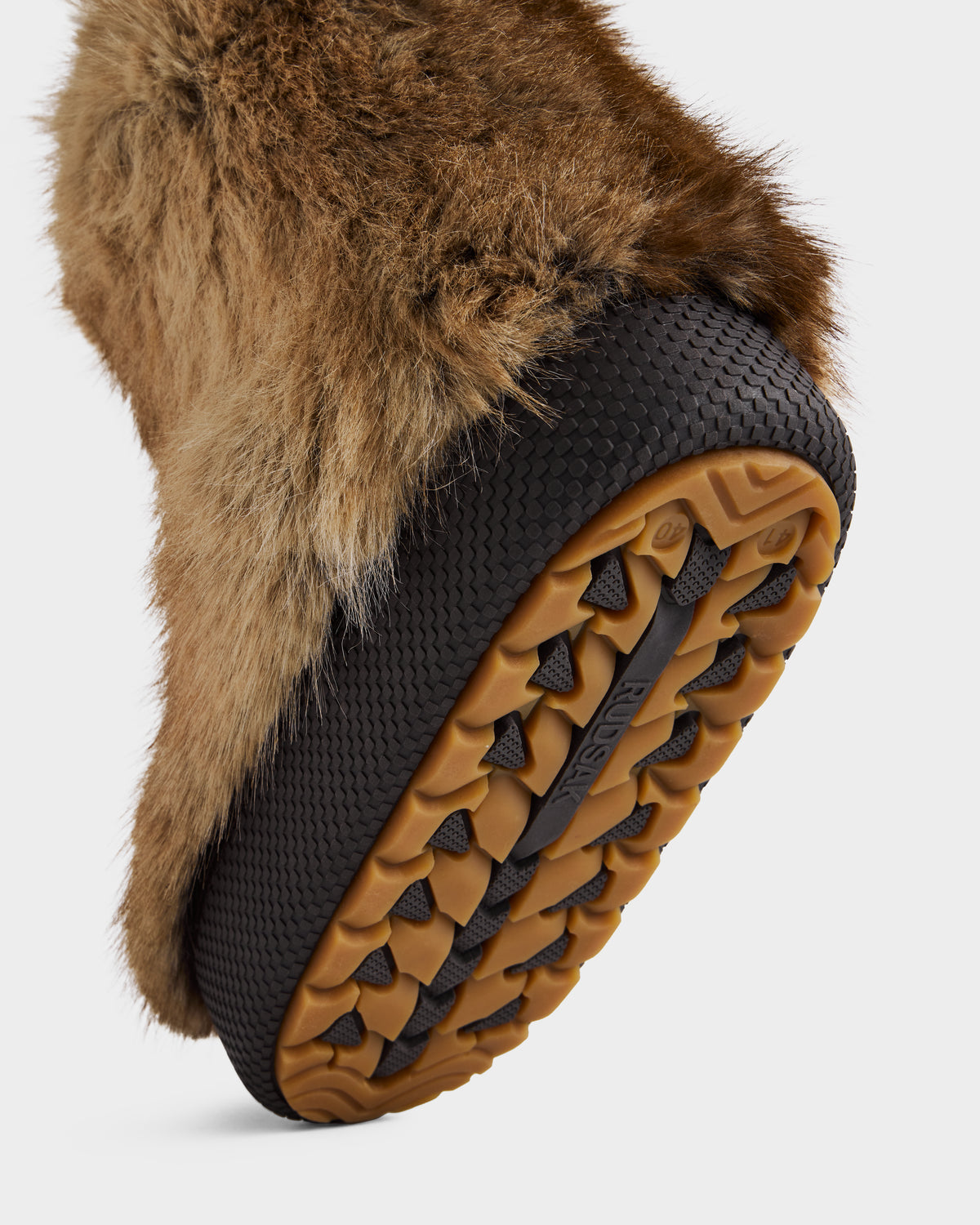 A close-up of the Rudsak SUZIE - 8225052 Mix Mocha women’s faux fur moon boot highlights its textured rubber sole with rugged tread for traction—the ideal winter statement boot for cozy warmth and style.
