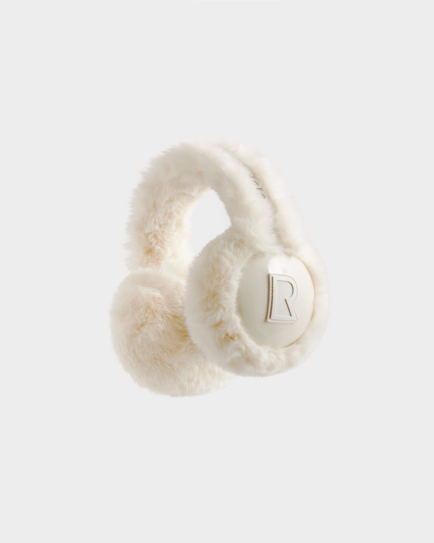 Stay cozy this winter with the VALENCIA - 8425543 Iceland earmuffs by Rudsak—features fluffy white faux fur, soft texture, and a stylish raised letter R on one ear, set against a sleek light gray background.