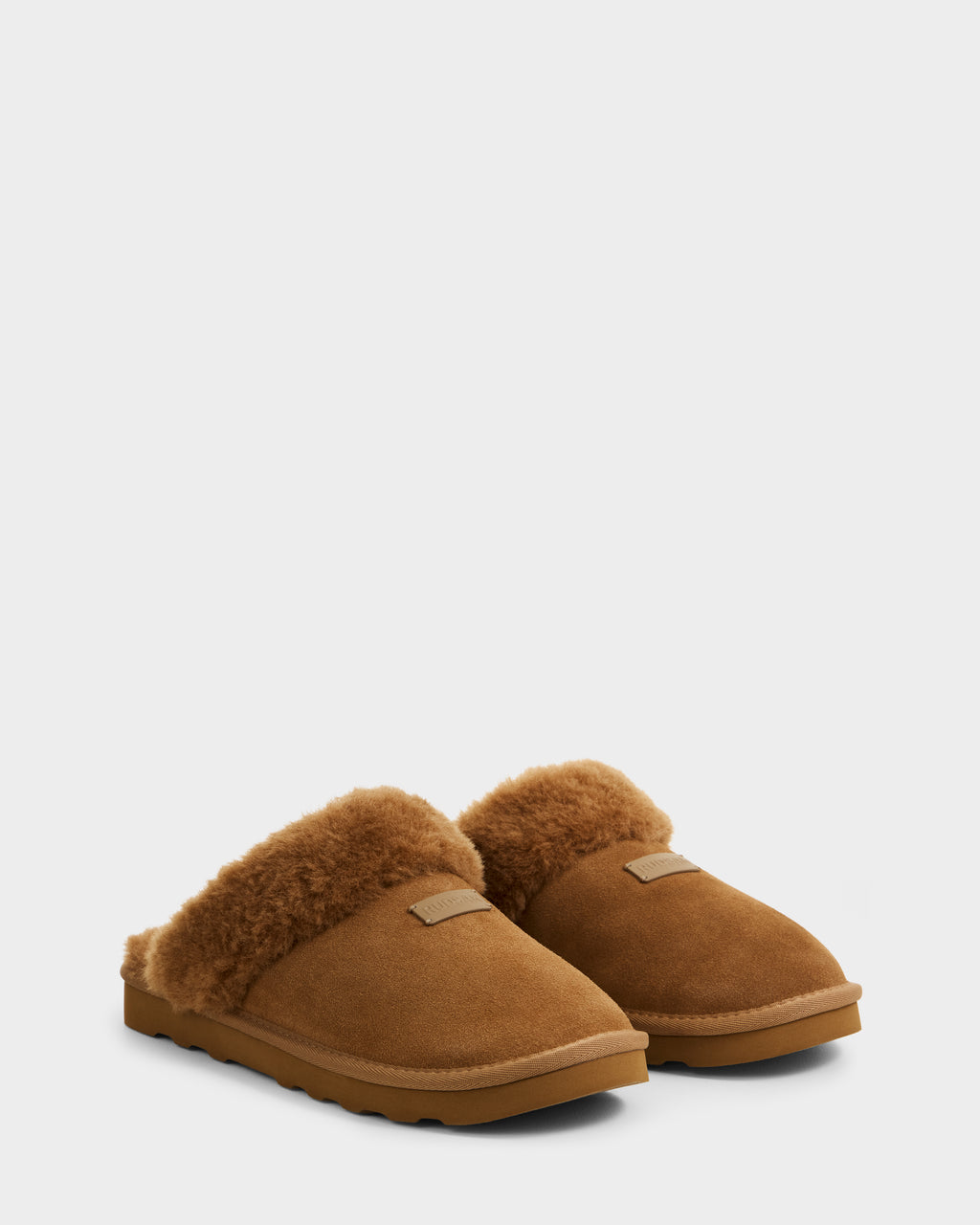 The Rudsak WILBER - 6225509 Tan men’s suede slippers feature a plush faux shearling lining and durable rubber soles, perfect for relaxing at home, shown here in brown against a plain white background.