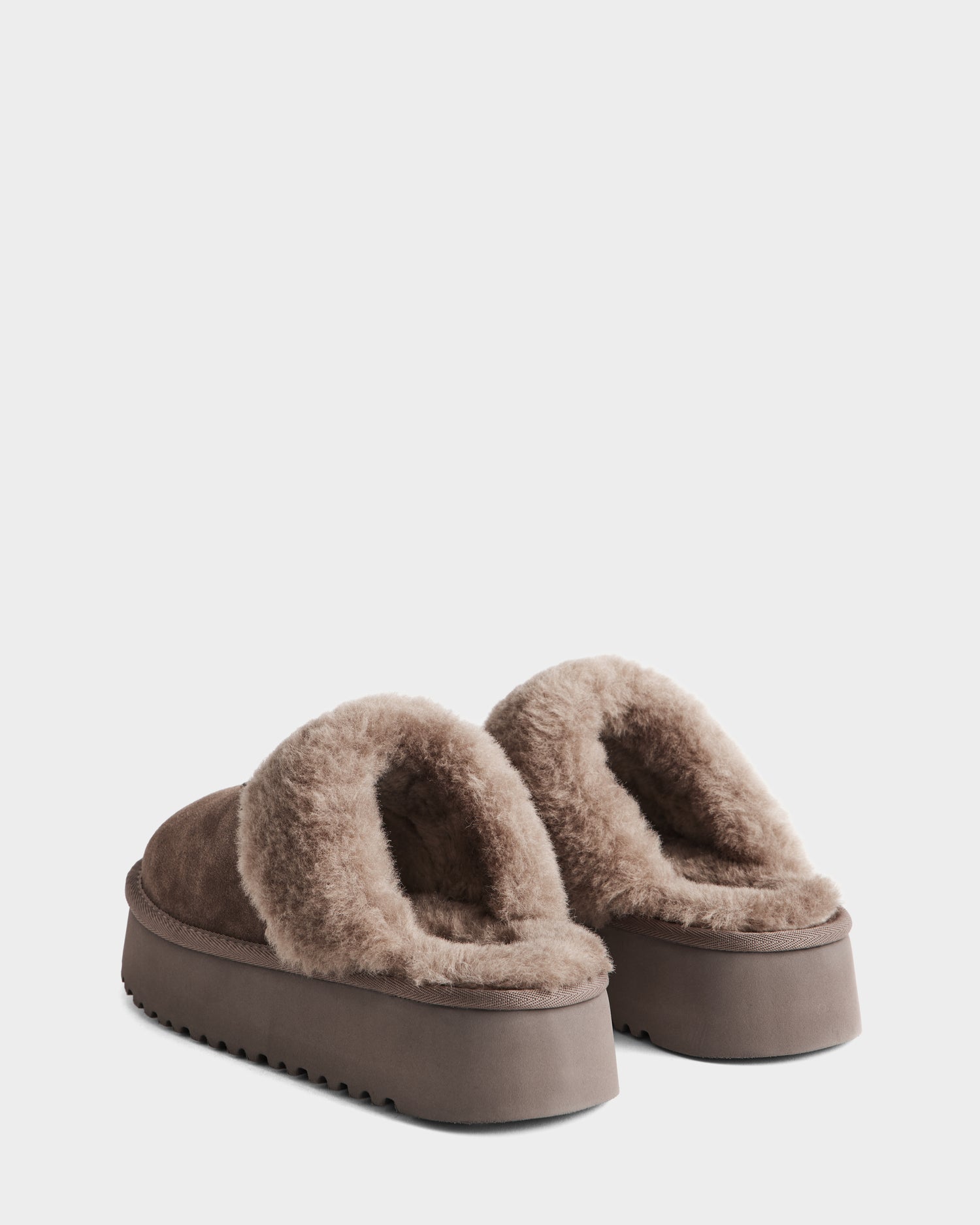 The Rudsak WILMA - 8225582 Mocha women’s slippers feature a brown fuzzy exterior, thick plush lining, and chunky platform soles; shown from the back on a plain white background.