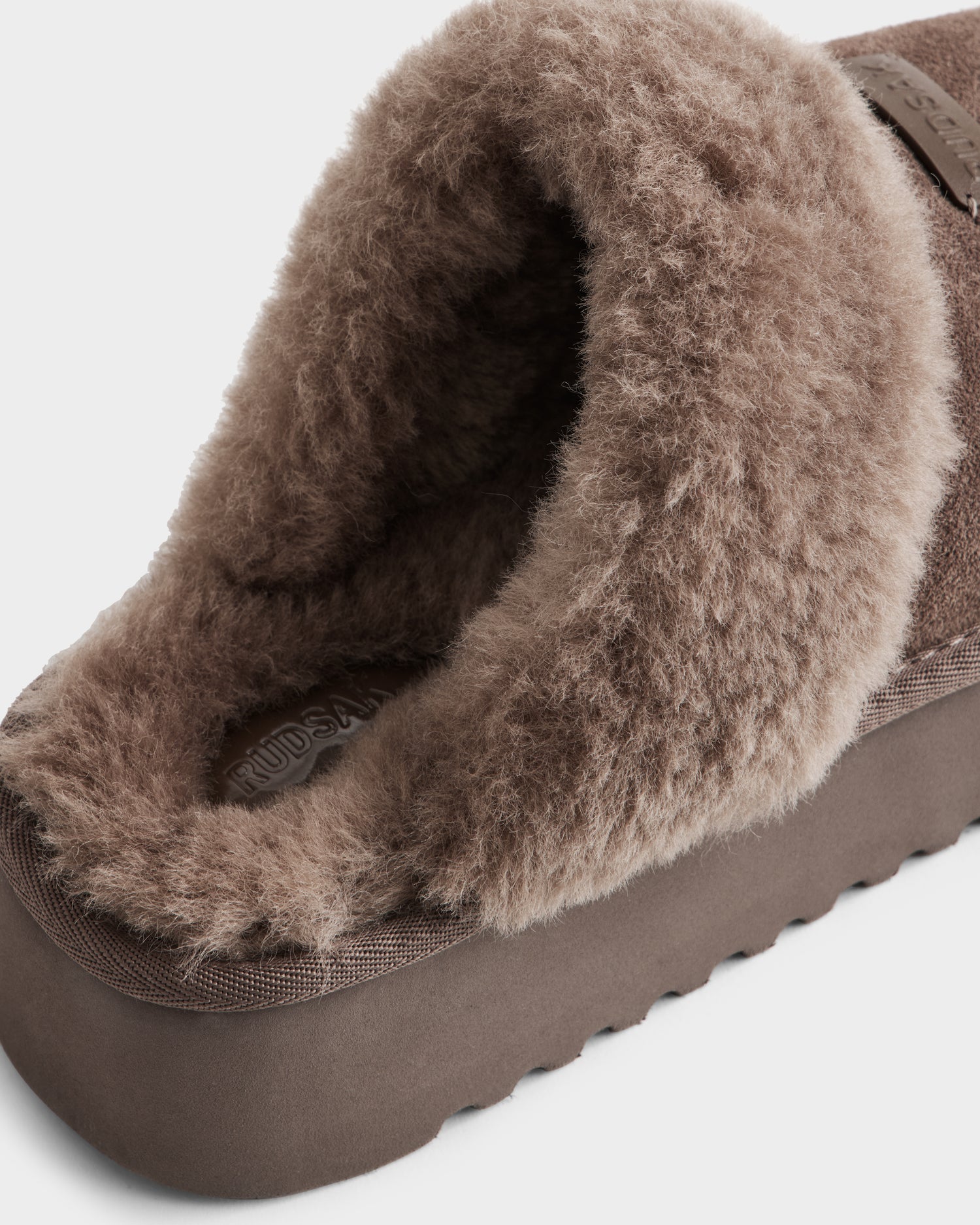 Close-up of the Rudsak WILMA - 8225582 Mocha women’s slipper in brown suede, featuring a plush furry lining and textured ridged sole—ideal for cozy indoor comfort.