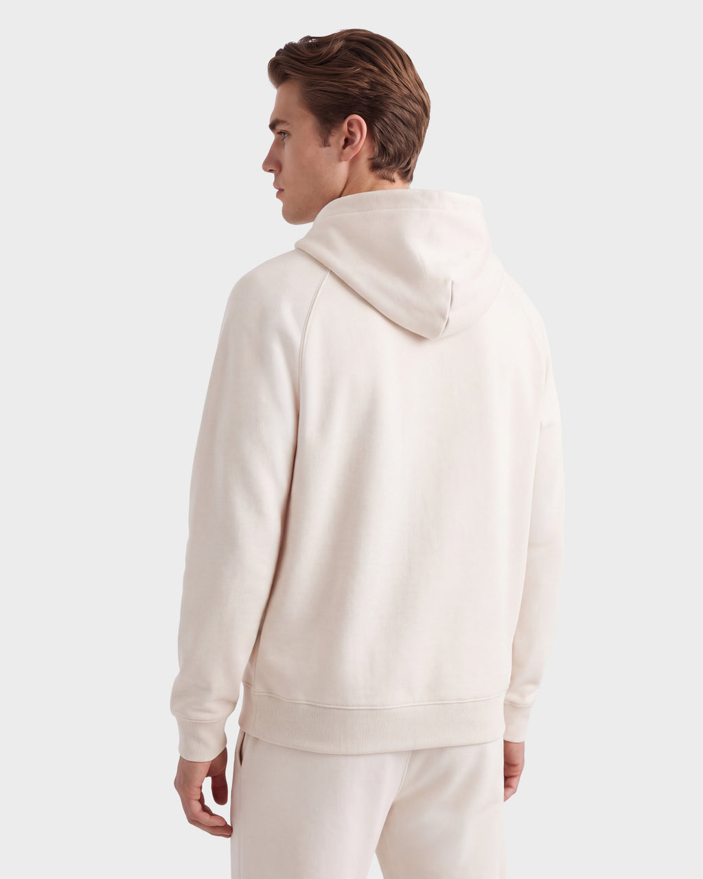 A man is standing with his back to the camera, looking to the left, wearing the Rudsak BRIAR R HV - H525506 Vanilla set against a plain light gray background.