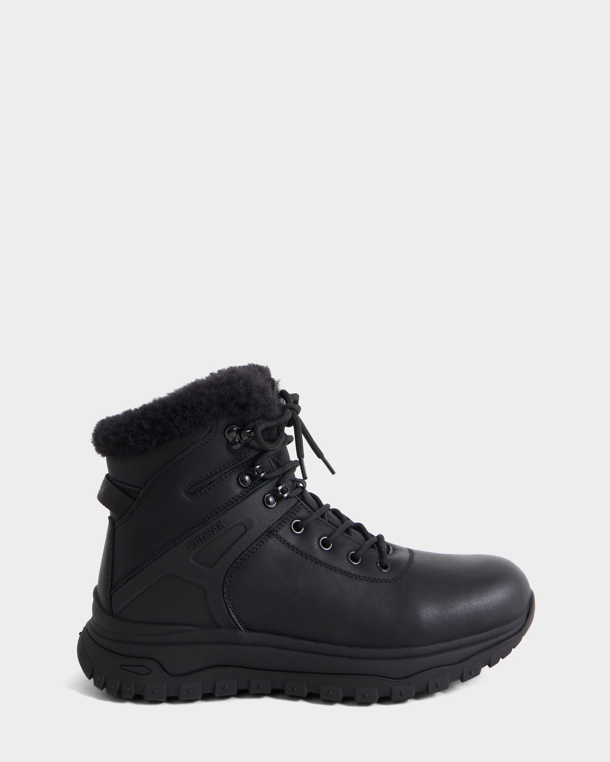 The BRYSON - 6226504 Black by Rudsak is a black leather winter boot with a lace-up design, thick lugged outsole, metal eyelets, black laces, and a fuzzy collar on a plain white background.