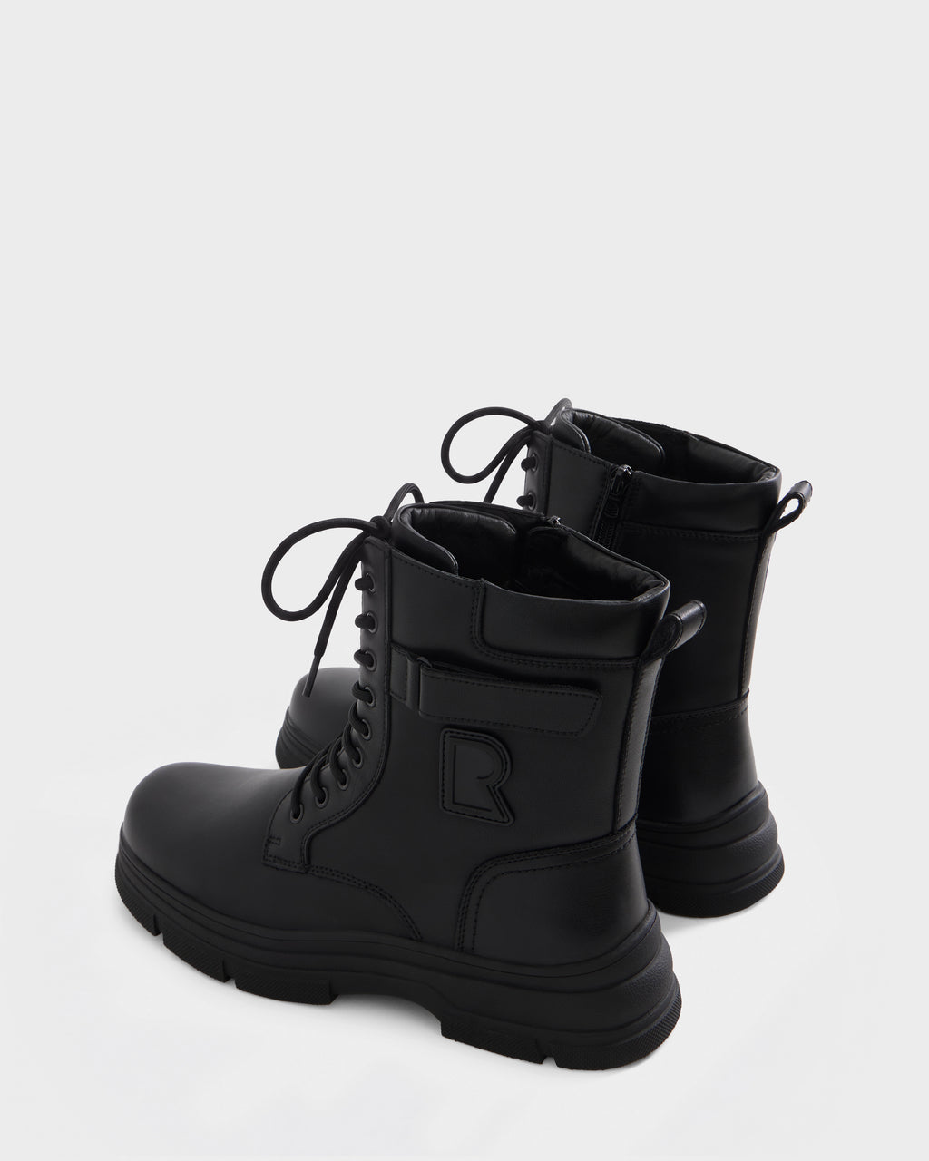 The DEREK - 6226506 Black by Rudsak are black lace-up combat boots with side zippers, textured soles, and a raised R detail—stylish winter footwear shown on a plain light background.