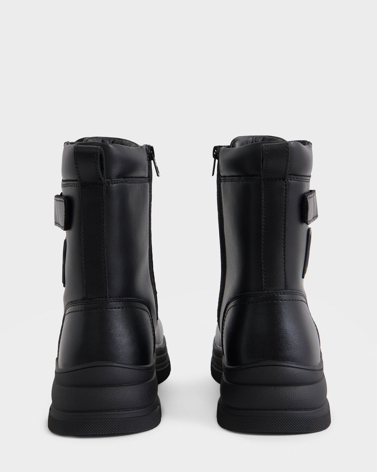 The DEREK - 6226506 Black by Rudsak: black combat boots with zippers and a chunky sole, shown from the back against a plain white background.