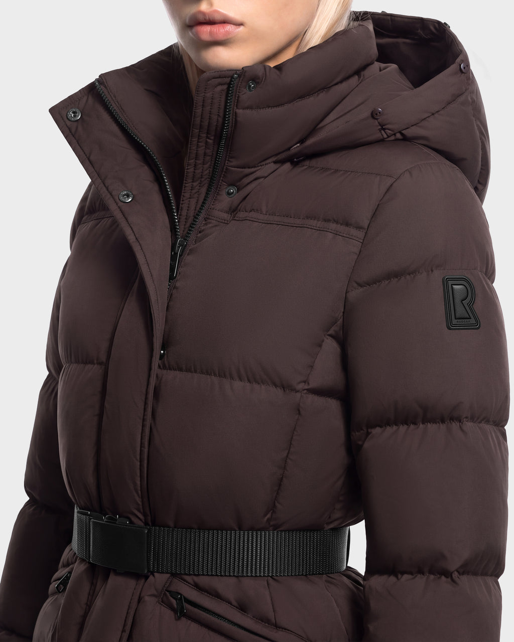 Rudsak GRACE FF - 8126535 Espresso dark brown hooded goose down puffer jacket with faux-fur detailing, a black webbed waist belt, and a rectangular logo patch on the left sleeve.