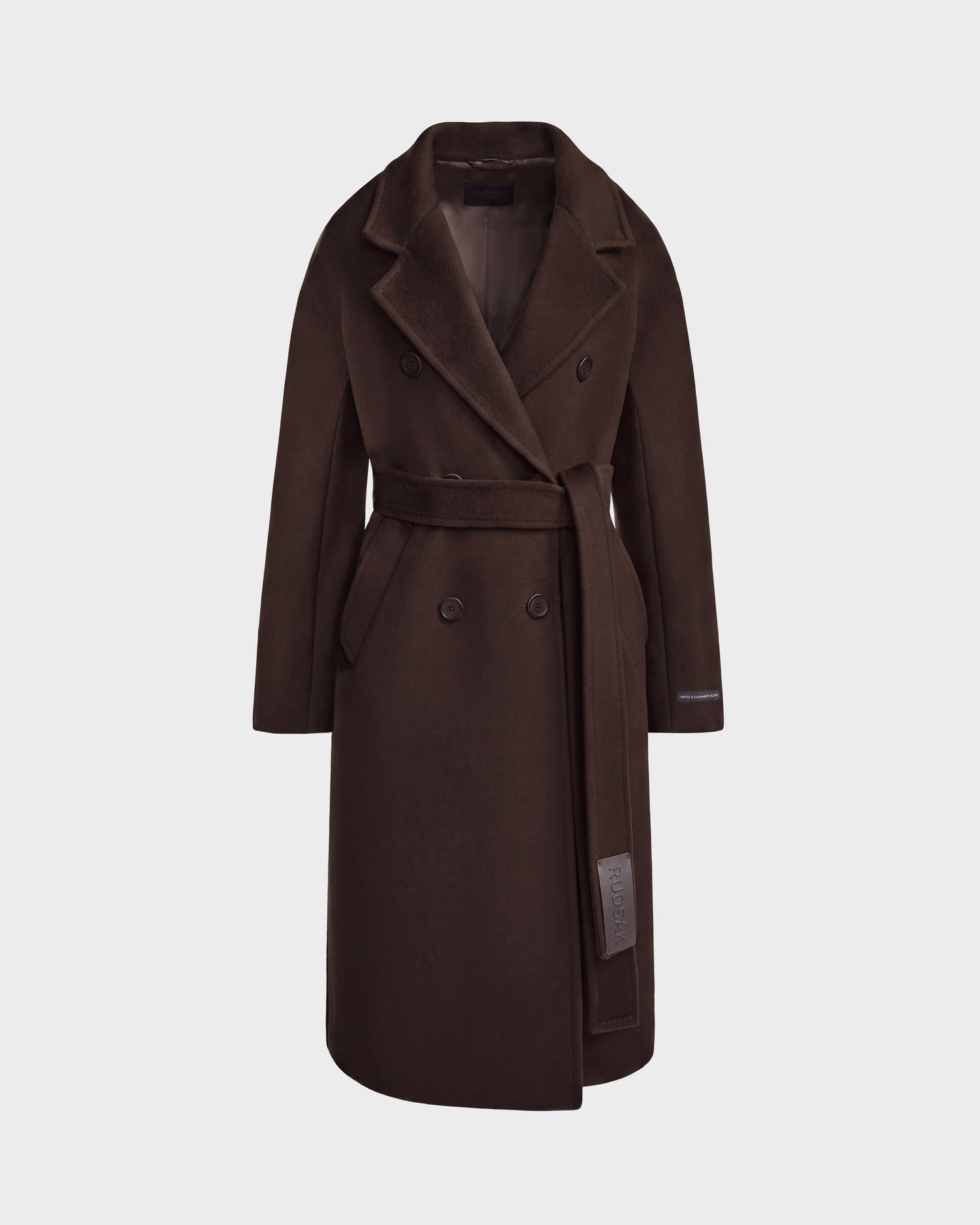 The KOURT W - 8124702 Espresso women's double-breasted coat by Rudsak is crafted from a luxurious wool and cashmere blend for enhanced warmth and softness. Featuring a rich dark brown hue, this sophisticated piece is designed with a wide collar, side pockets, and a matching belt tied at the waist. The coat is presented against a plain light background, highlighting its elegant silhouette.