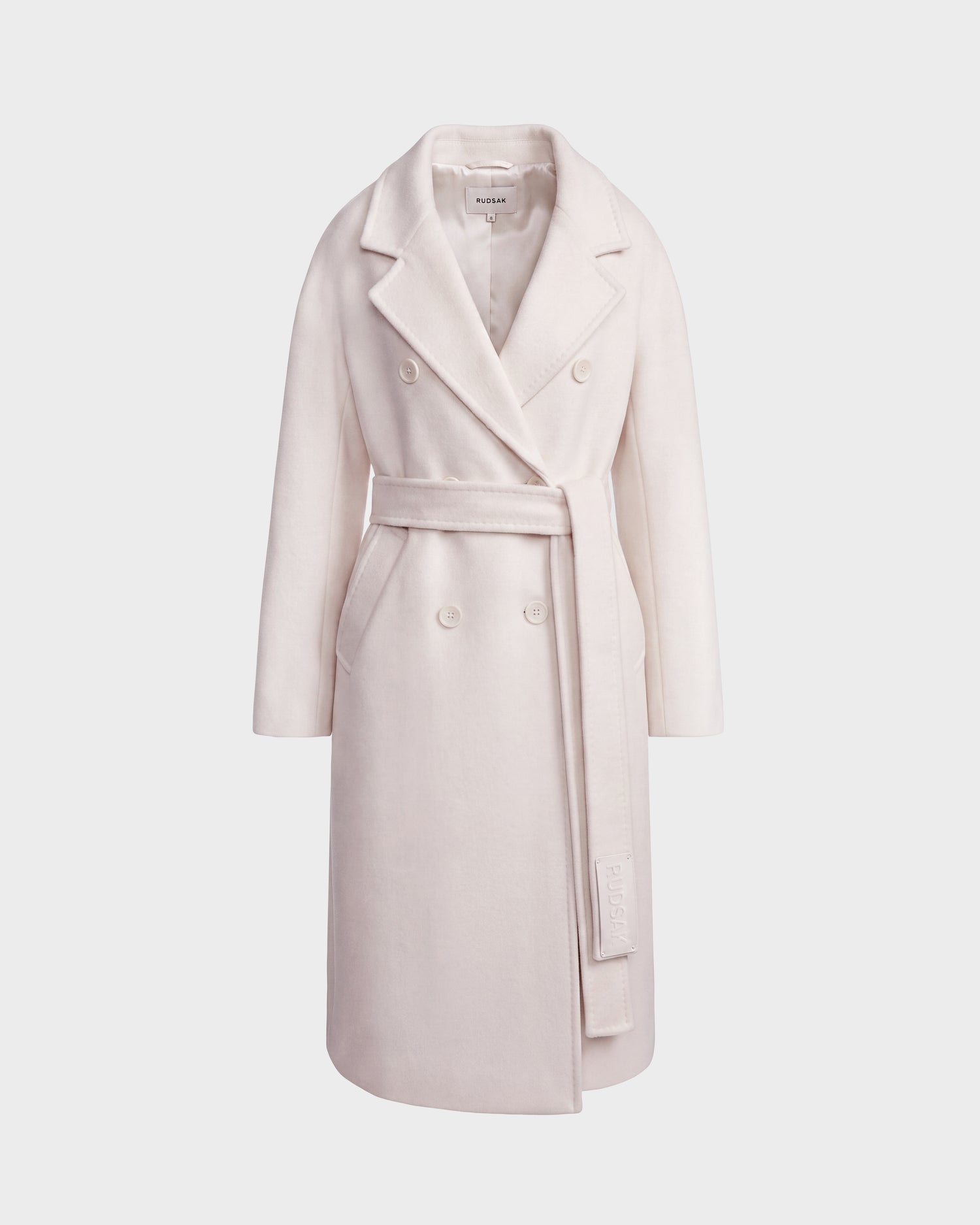 Introducing the KOURT W - 8124702 Vanilla by Rudsak: an elegant long, double-breasted women's wool coat in light beige featuring a belted waist, wide lapels, and side pockets—displayed on a plain white background.