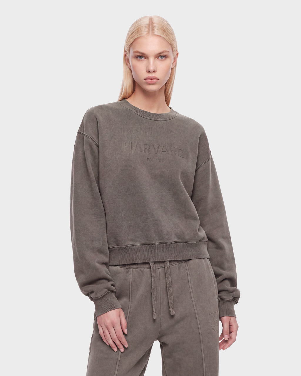A woman with long blonde hair wears the Rudsak LEXYE HV - H526900 Taupe set, standing against a plain white background.