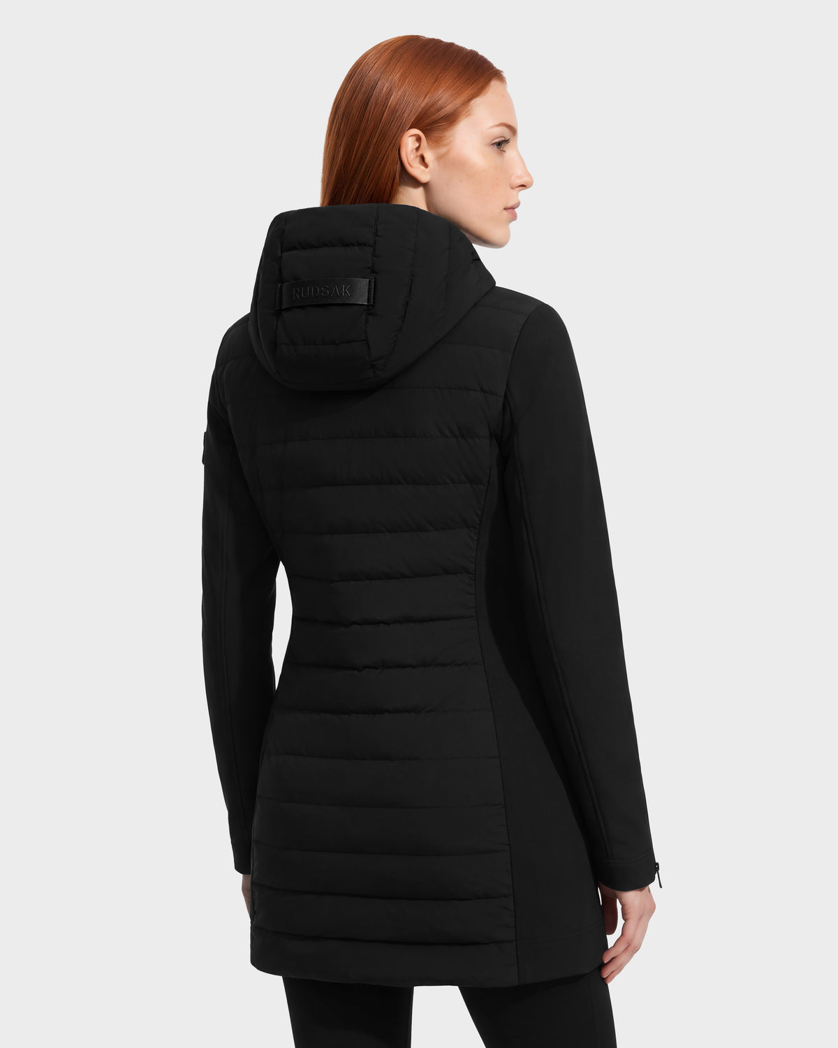 Back view of a woman wearing a black, fitted MERINA - 8125056 Black quilted down jacket with a hood.