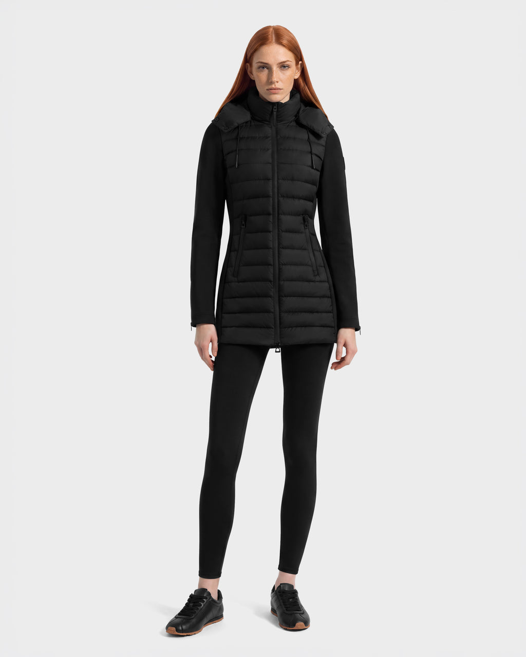 A person wearing a black Rudsak MERINA - 8125056 Black quilted down jacket with smooth sleeves, paired with black leggings and black sneakers.