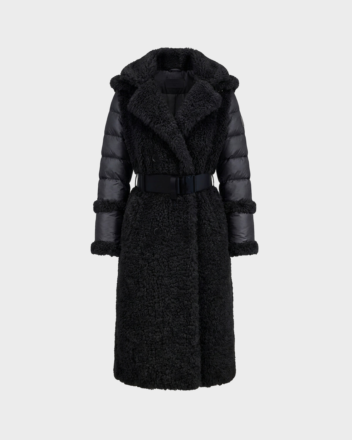 The Rudsak NOELLE - 8126971 Black is a long black faux fur coat featuring a textured, fuzzy body, padded sleeves, a wide collar, and a matching belt at the waist. Displayed against a plain light gray background, this stylish women’s winter coat offers both warmth and elegance for the colder months.