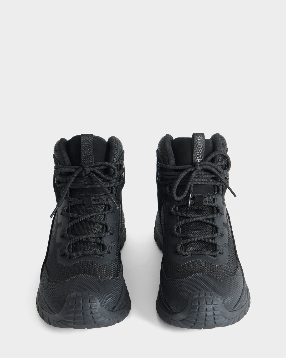 A pair of Rudsak REXON - 6226503 black high-top sneakers featuring thick rubber soles, black laces, and forward-facing tongue tabs displayed on a plain white background.
