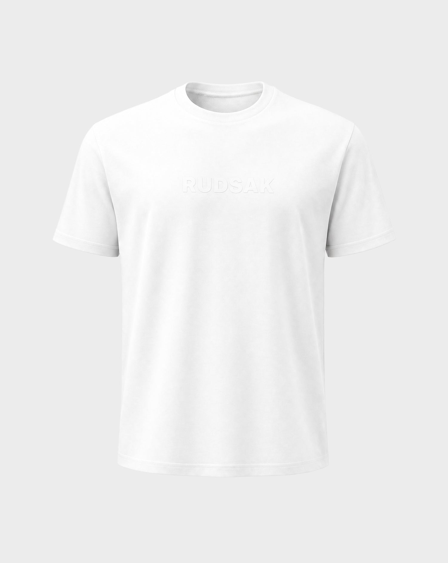 The FERDI - 6522005 Natural White by Rudsak is a plain white short-sleeve t-shirt with RUDSAK subtly embossed on the front, shown against a light gray background.